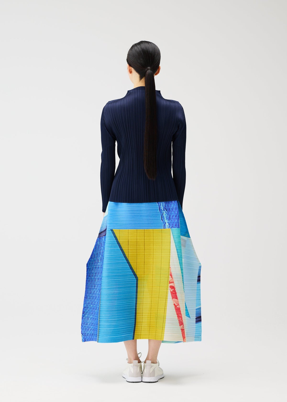 A model wears the PLEATS PLEASE ISSEY MIYAKE CITY COLLAGE clothing.