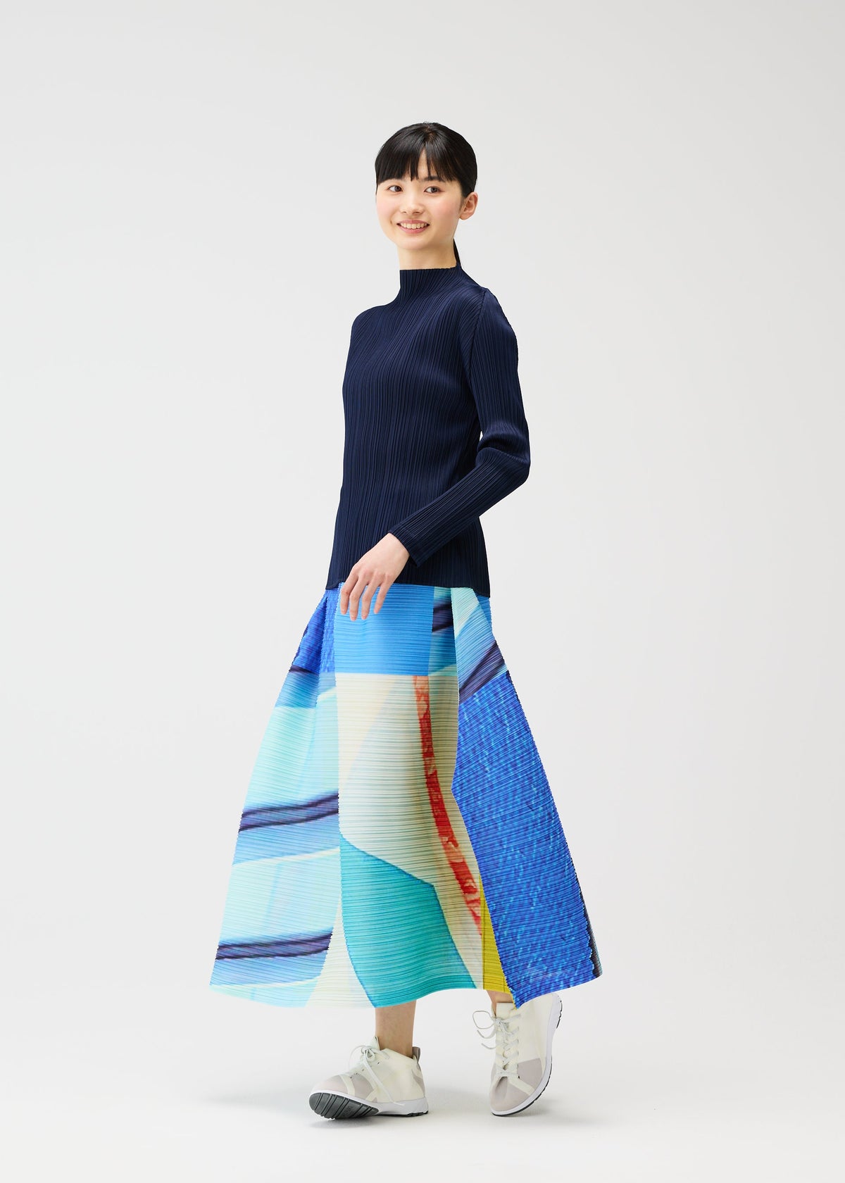 A model wears the PLEATS PLEASE ISSEY MIYAKE CITY COLLAGE clothing.