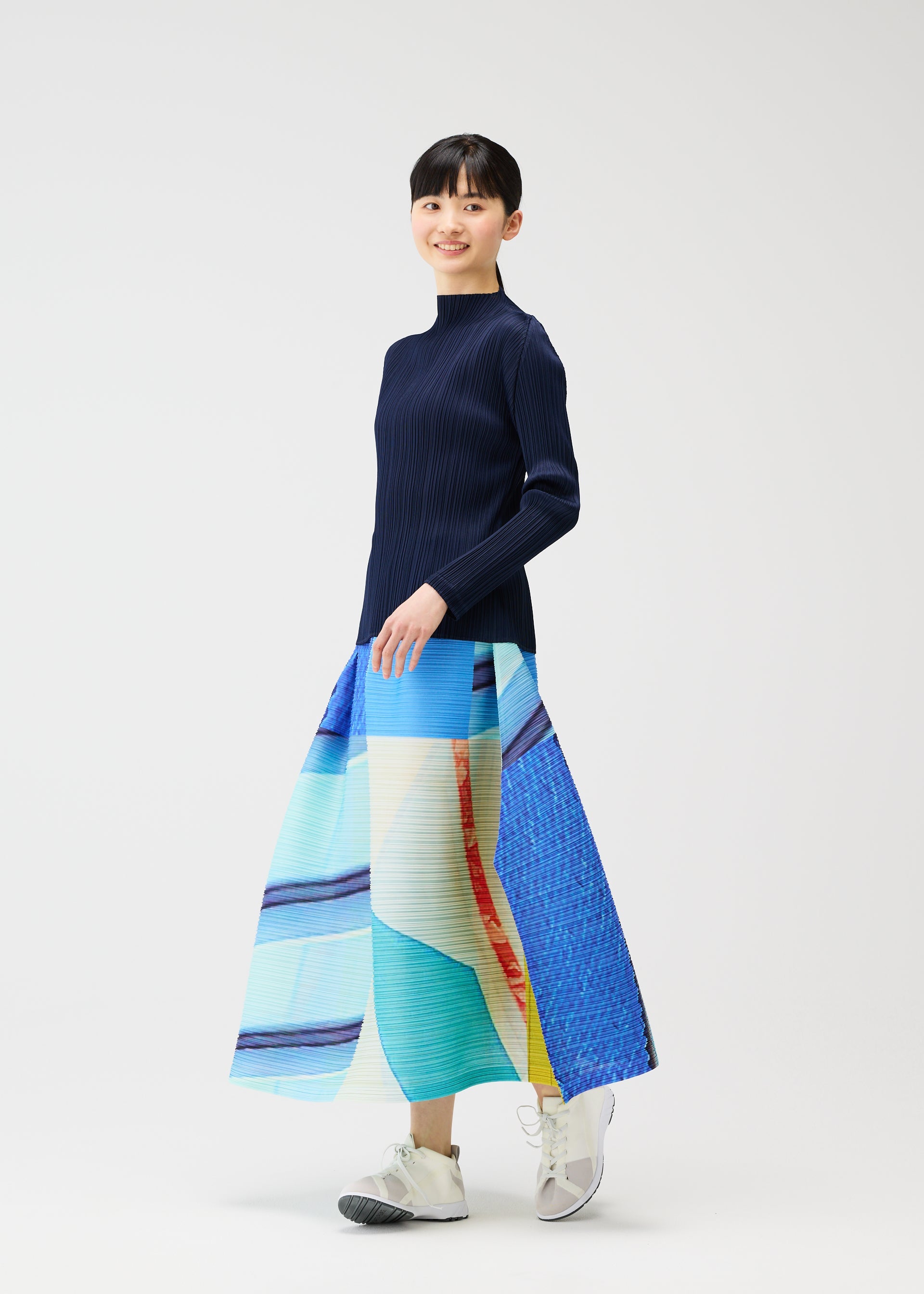 A model wears the PLEATS PLEASE ISSEY MIYAKE CITY COLLAGE clothing.