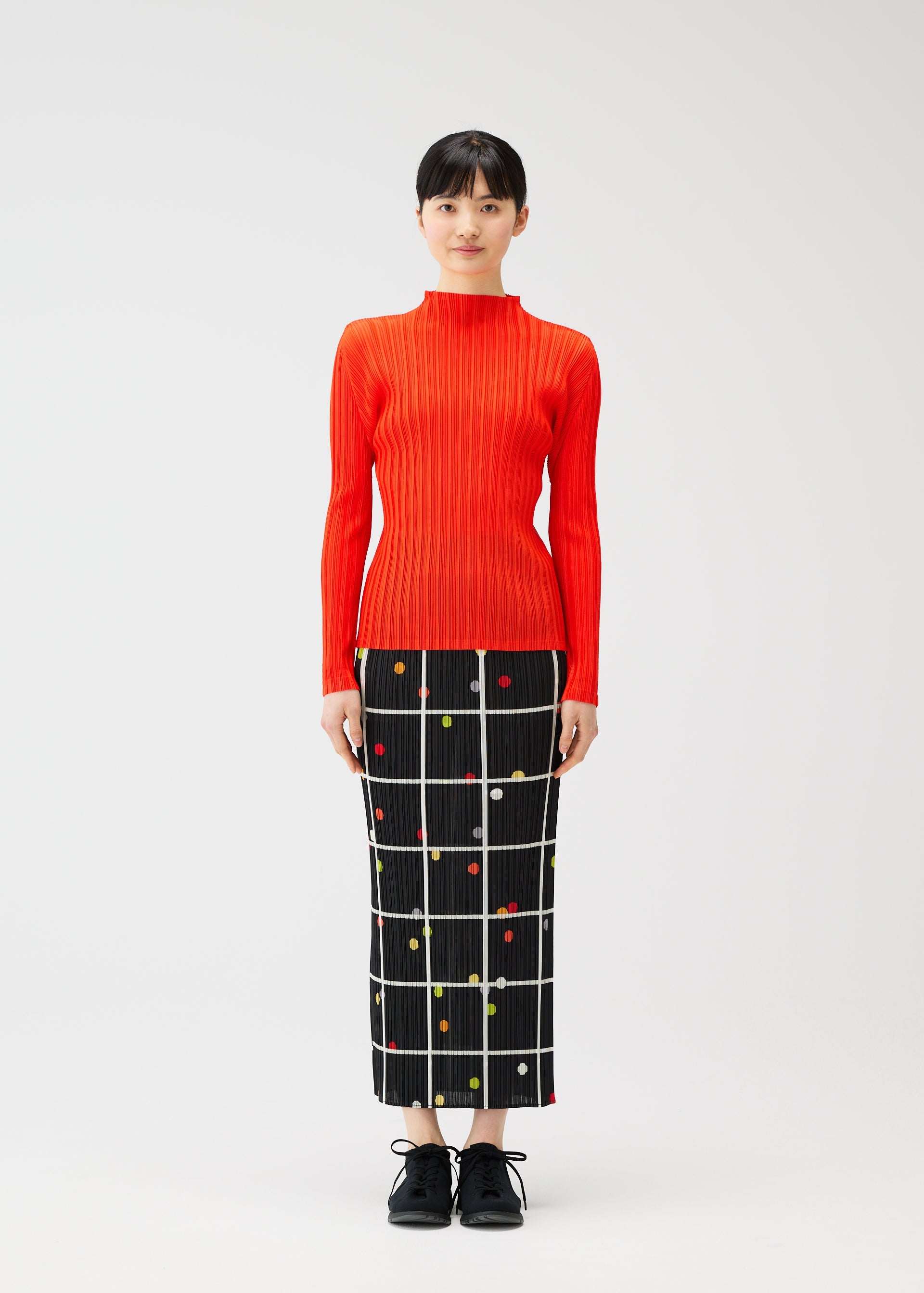 A model wears the PLEATS PLEASE ISSEY MIYAKE CROSSING DOTS skirt.