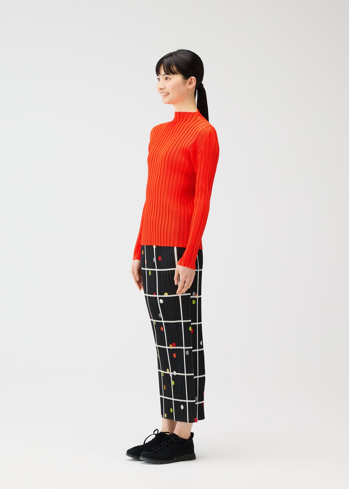 A model wears the PLEATS PLEASE ISSEY MIYAKE CROSSING DOTS skirt.