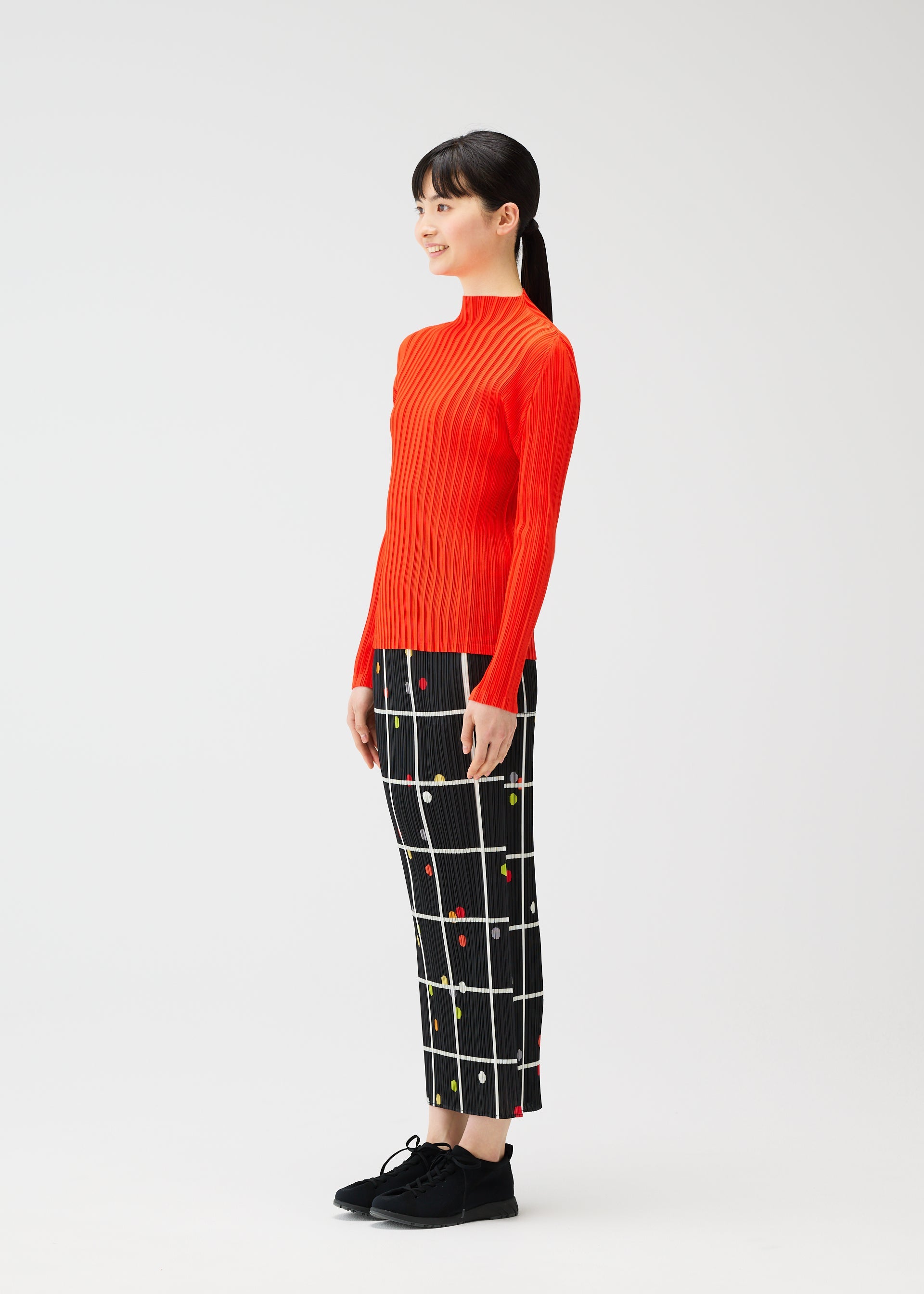 A model wears the PLEATS PLEASE ISSEY MIYAKE CROSSING DOTS skirt.