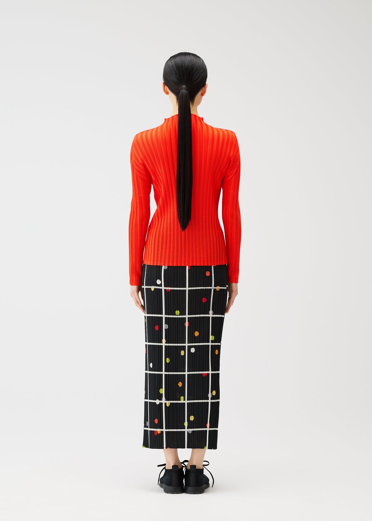 A model wears the PLEATS PLEASE ISSEY MIYAKE CROSSING DOTS skirt.