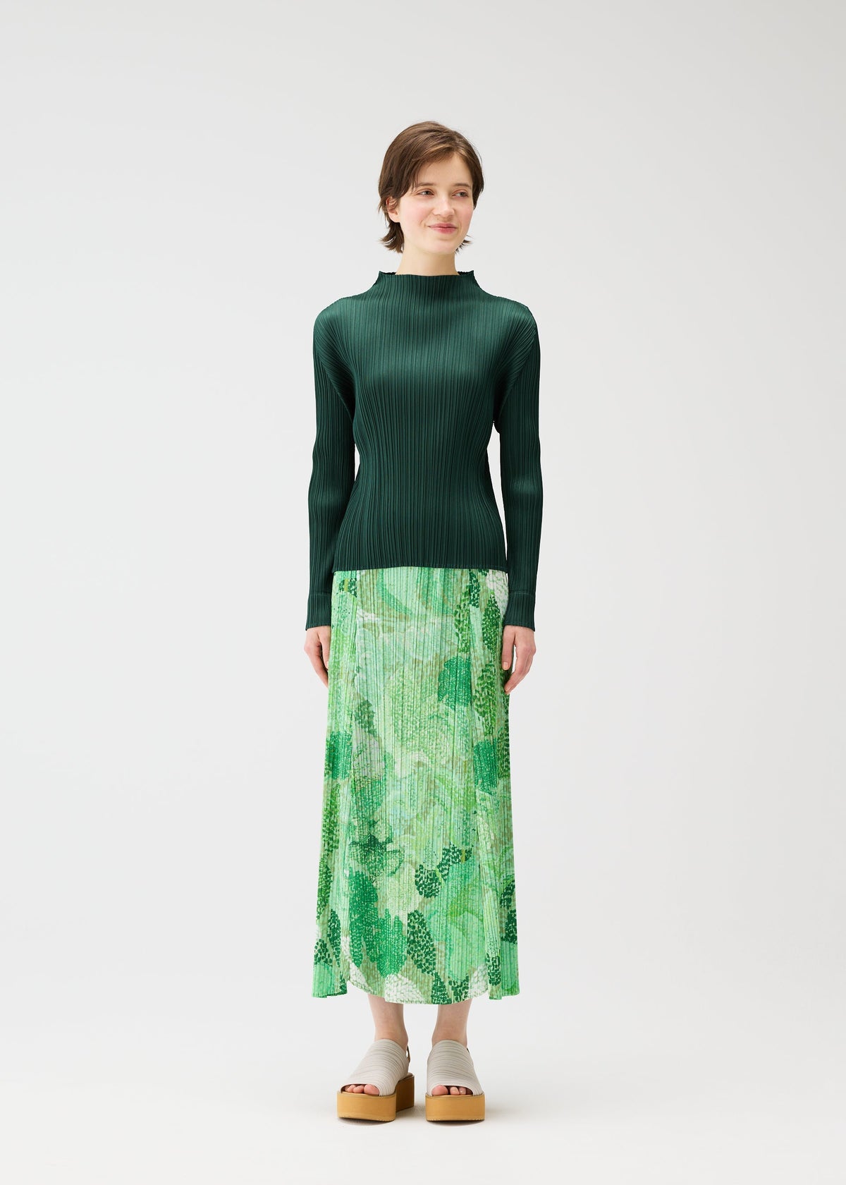 A model wears the PLEATS PLEASE ISSEY MIYAKE FOGGY FOREST skirt.