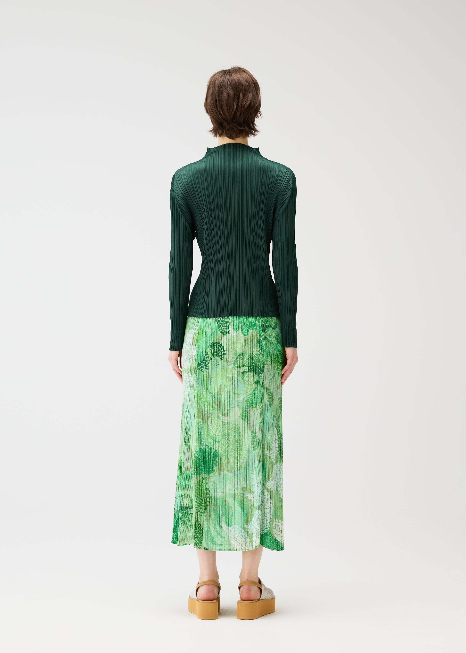 A model wears the PLEATS PLEASE ISSEY MIYAKE FOGGY FOREST skirt.
