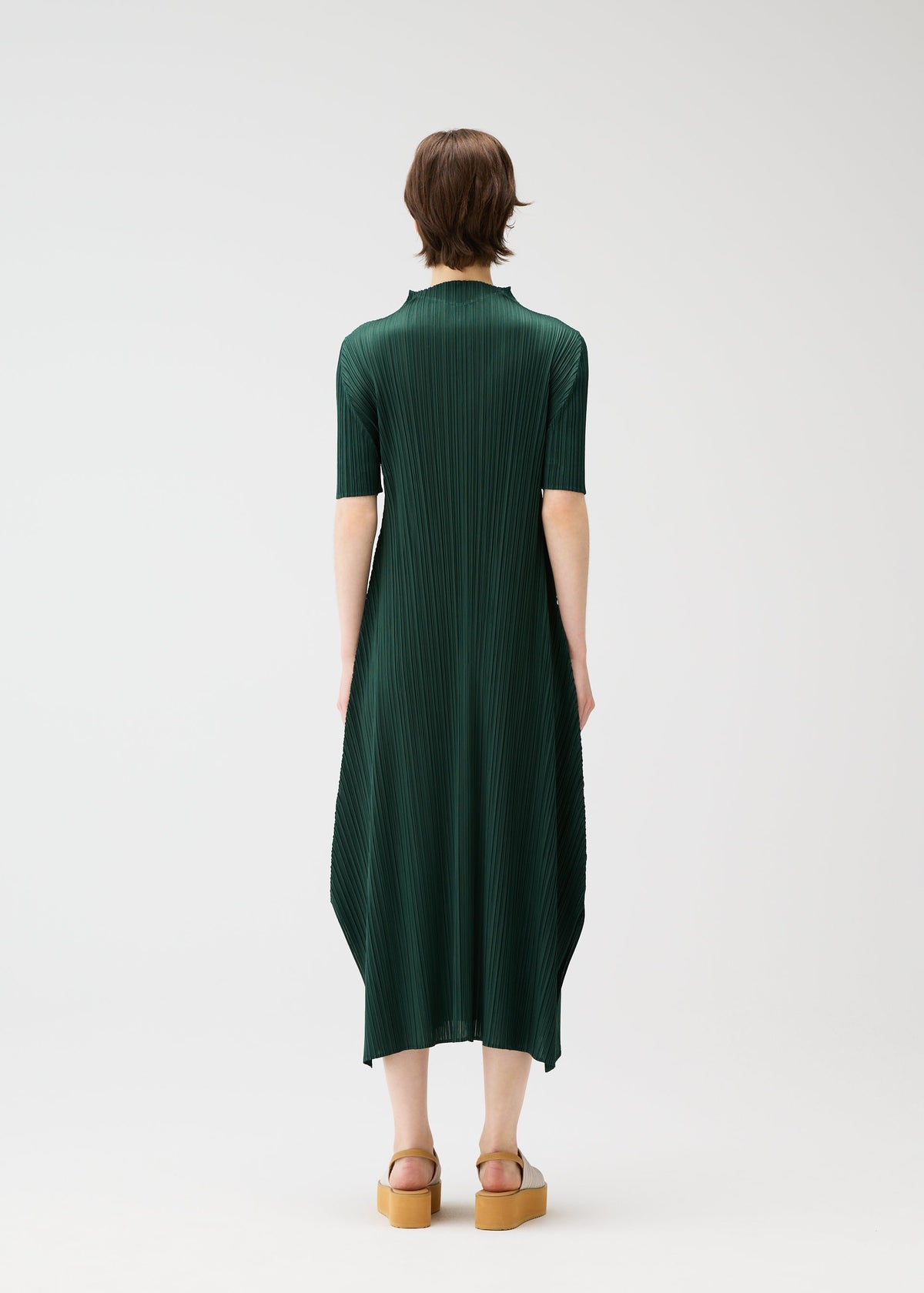 A model wears the PLEATS PLEASE ISSEY MIYAKE MONTHLY COLORS MARCH dress.