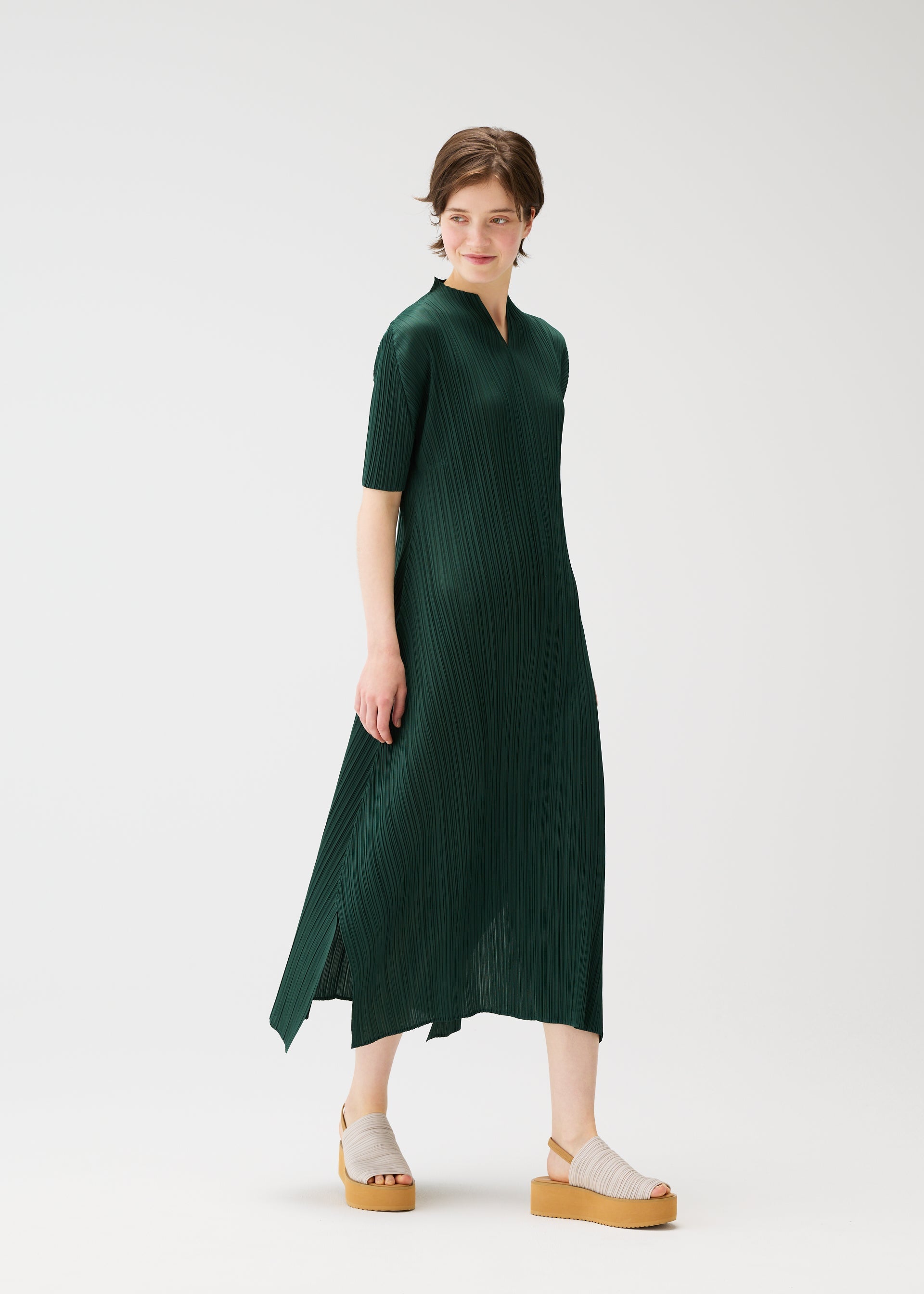 A model wears the PLEATS PLEASE ISSEY MIYAKE MONTHLY COLORS MARCH dress.