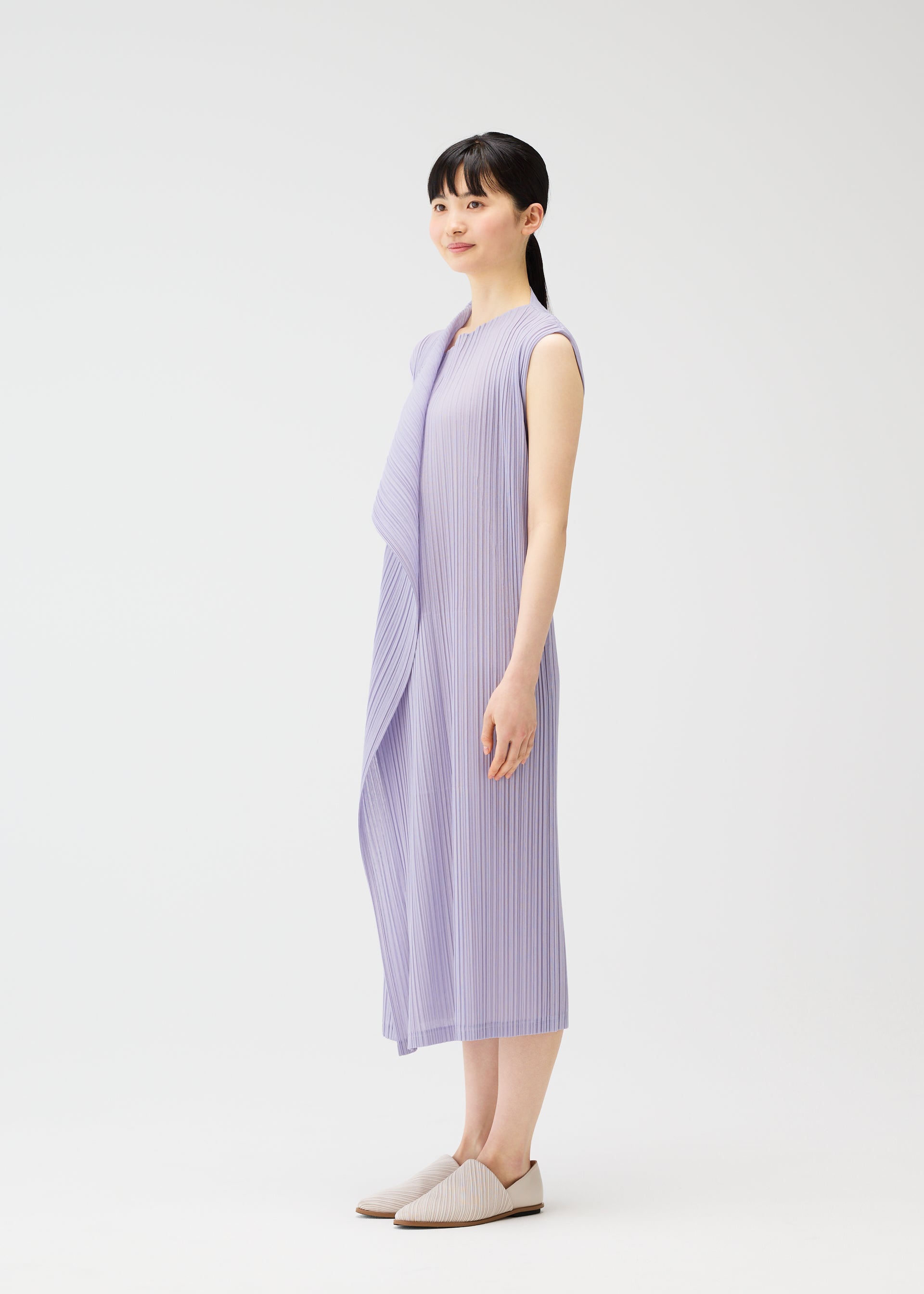 A model wears the PLEATS PLEASE ISSEY MIYAKE RAMIE PLEATS dress.