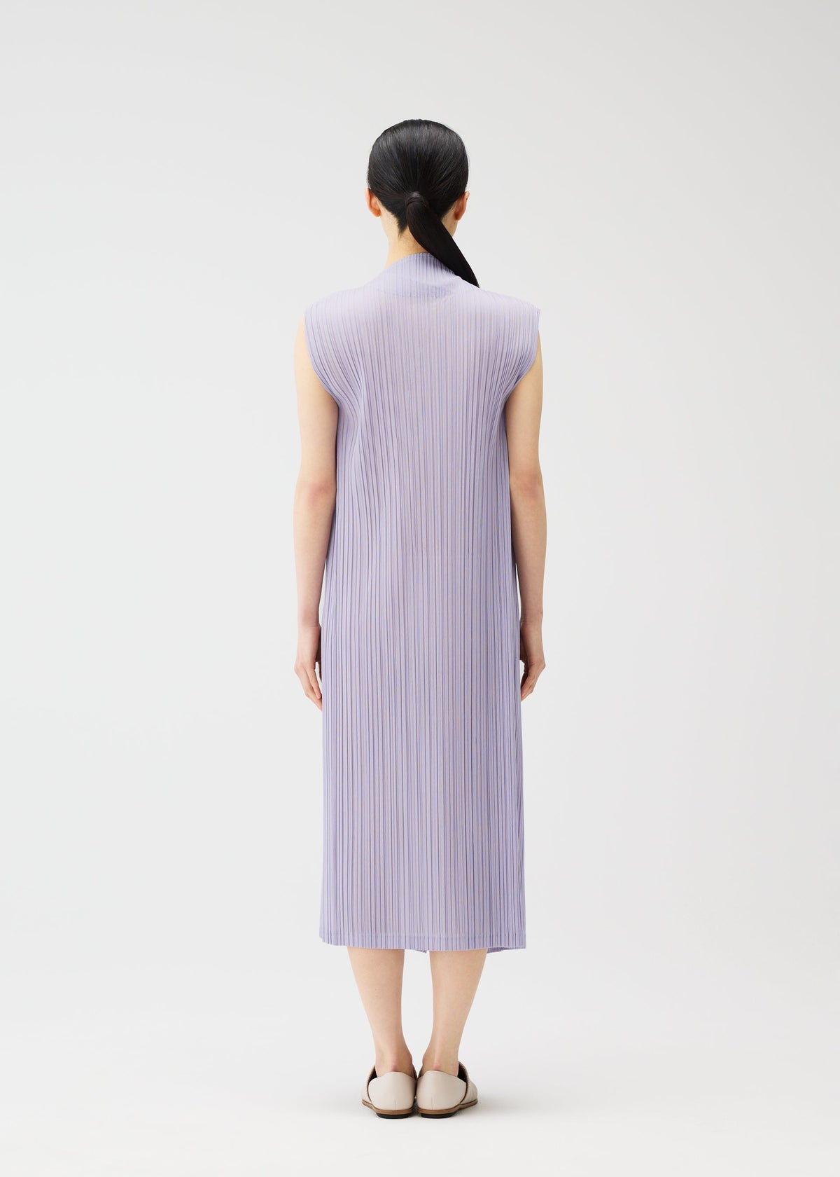 A model wears the PLEATS PLEASE ISSEY MIYAKE RAMIE PLEATS dress.