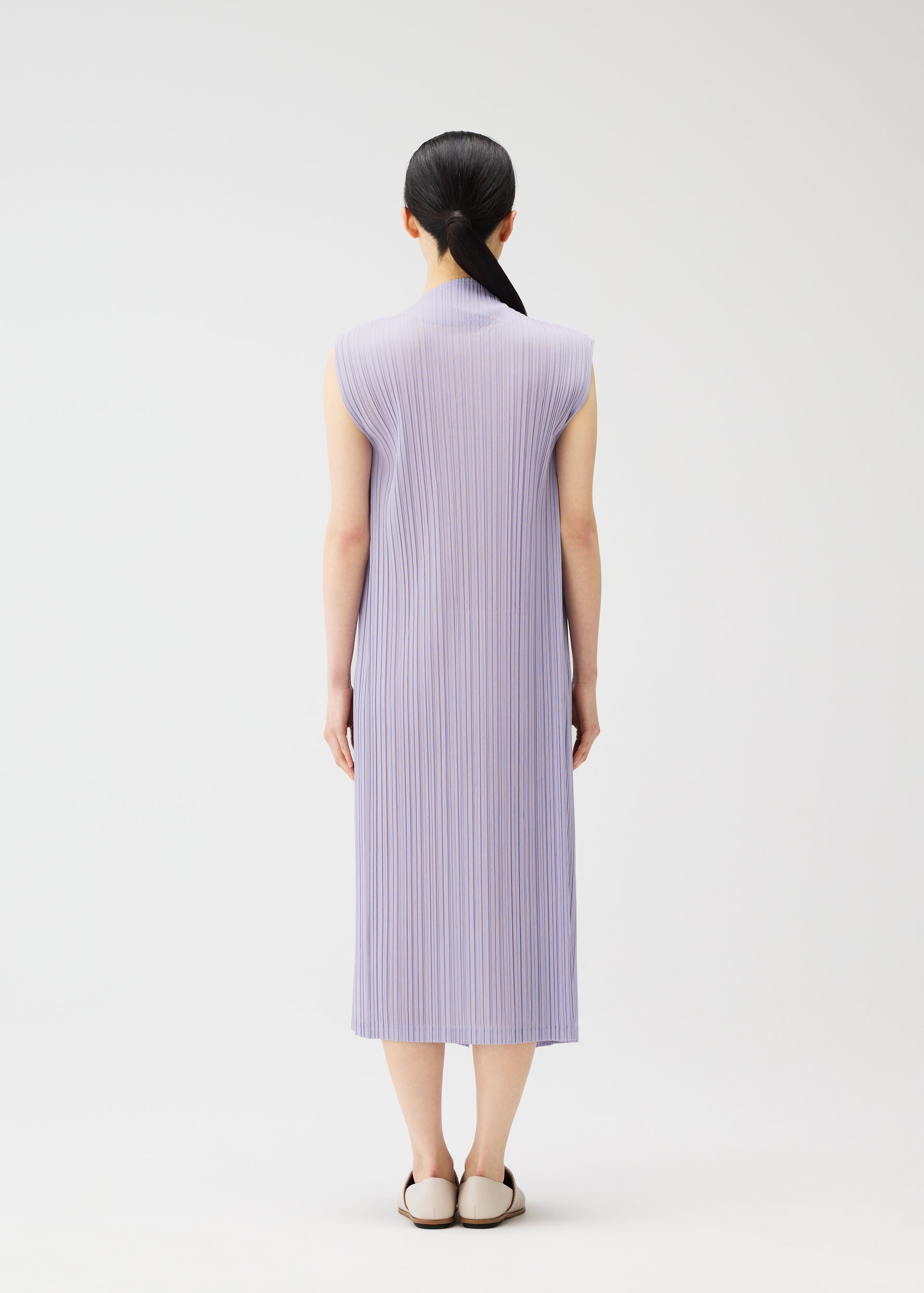 A model wears the PLEATS PLEASE ISSEY MIYAKE RAMIE PLEATS dress.
