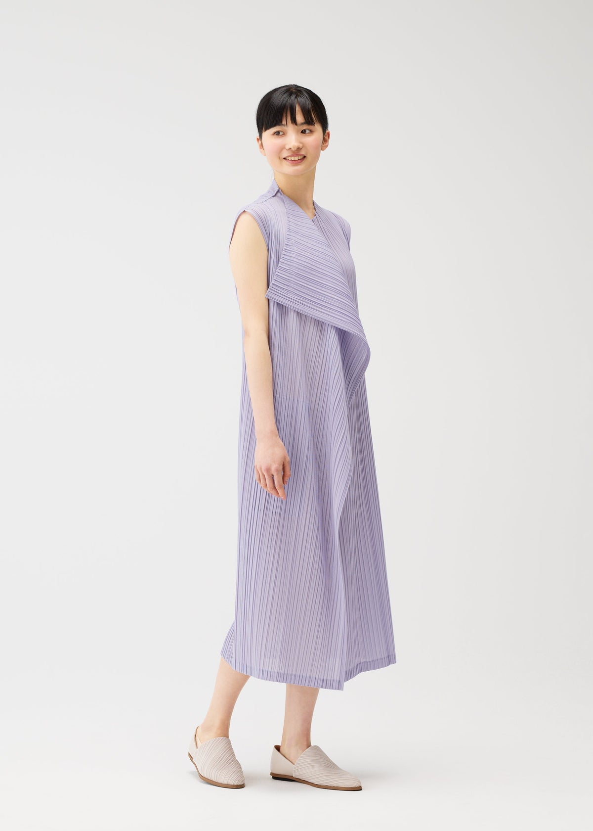 A model wears the PLEATS PLEASE ISSEY MIYAKE RAMIE PLEATS dress.