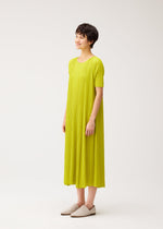 A model wears the PLEATS PLEASE ISSEY MIYAKE MELLOW PLEATS dress.