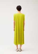 A model wears the PLEATS PLEASE ISSEY MIYAKE MELLOW PLEATS dress.