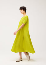 A model wears the PLEATS PLEASE ISSEY MIYAKE MELLOW PLEATS dress.