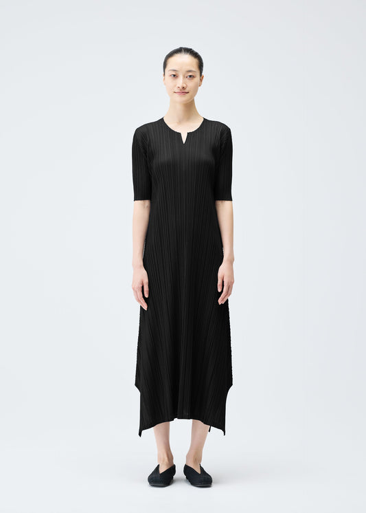 A model wears the PLEATS PLEASE ISSEY MIYAKE MELLOW PLEATS dress.
