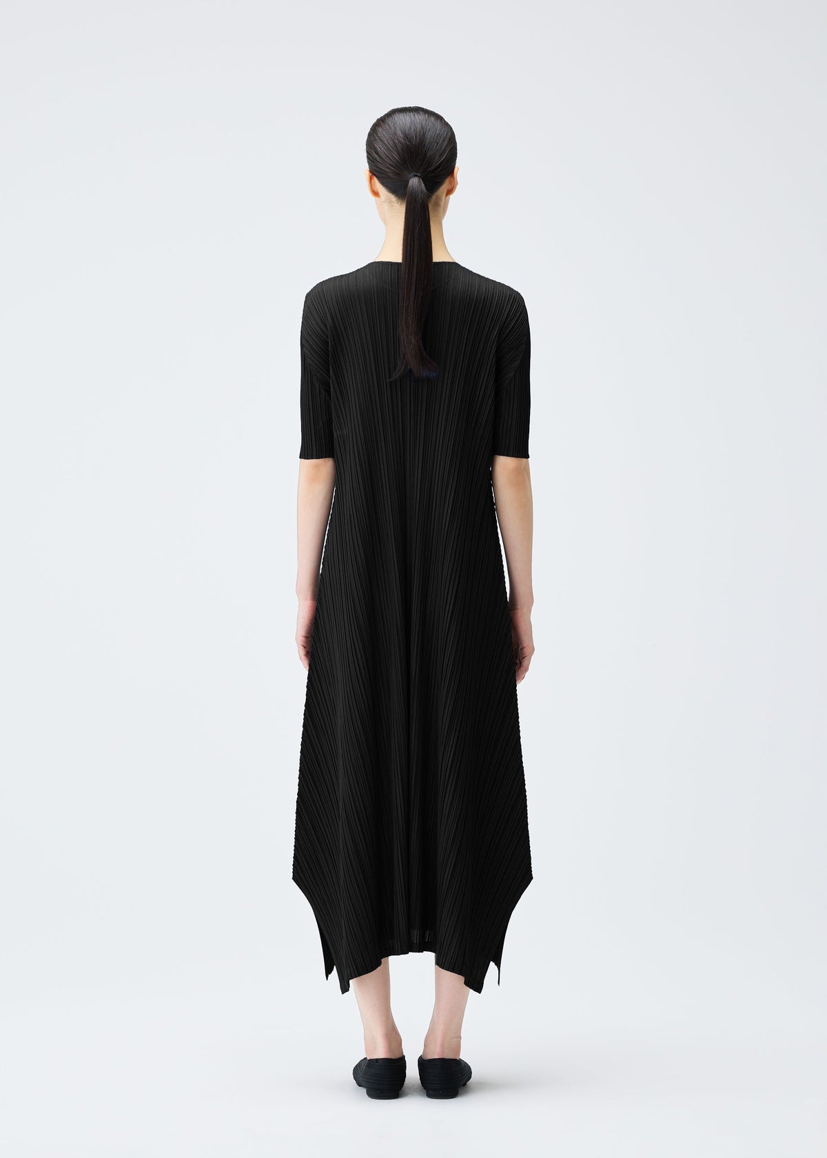 A model wears the PLEATS PLEASE ISSEY MIYAKE MELLOW PLEATS dress.