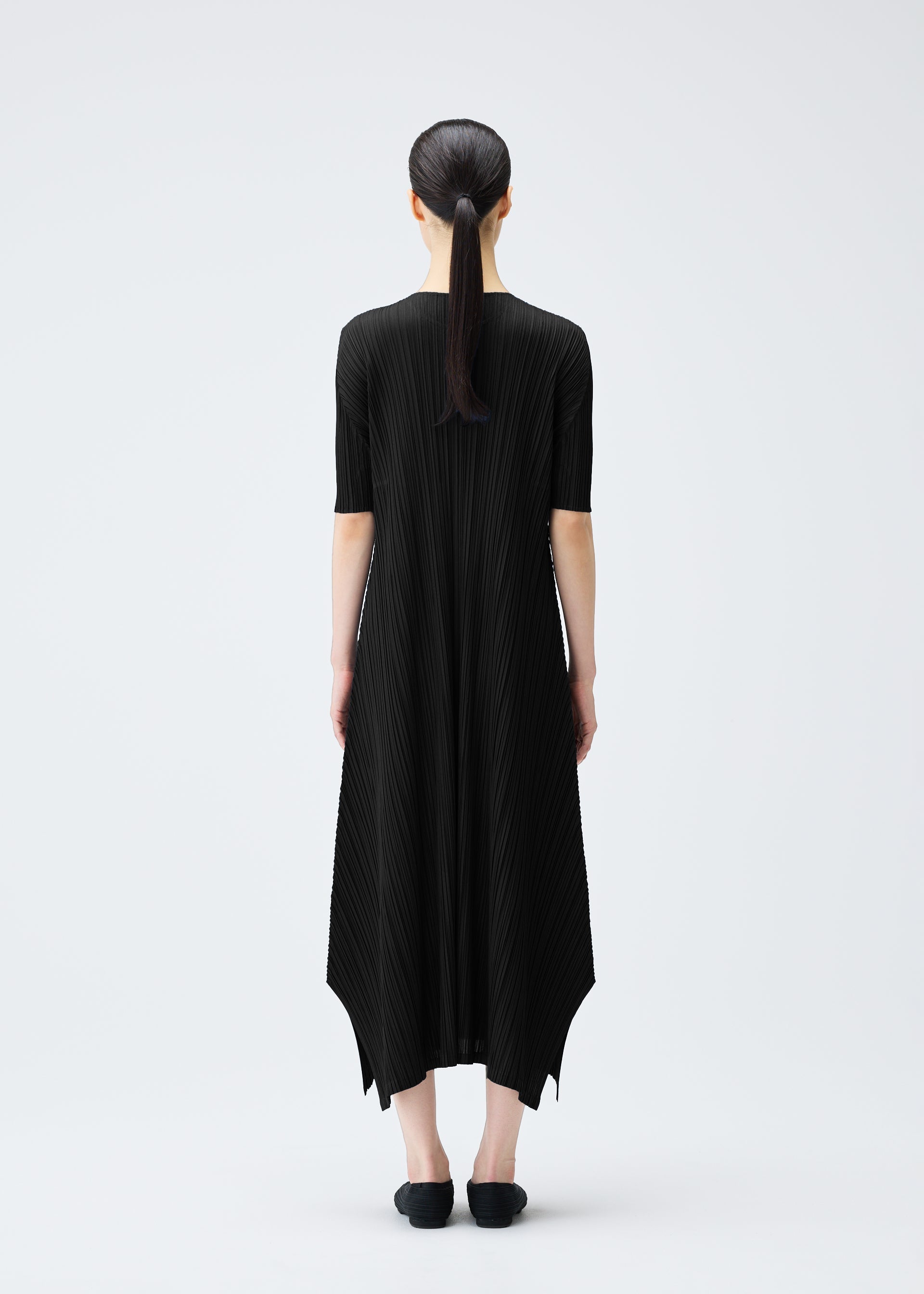 A model wears the PLEATS PLEASE ISSEY MIYAKE MELLOW PLEATS dress.