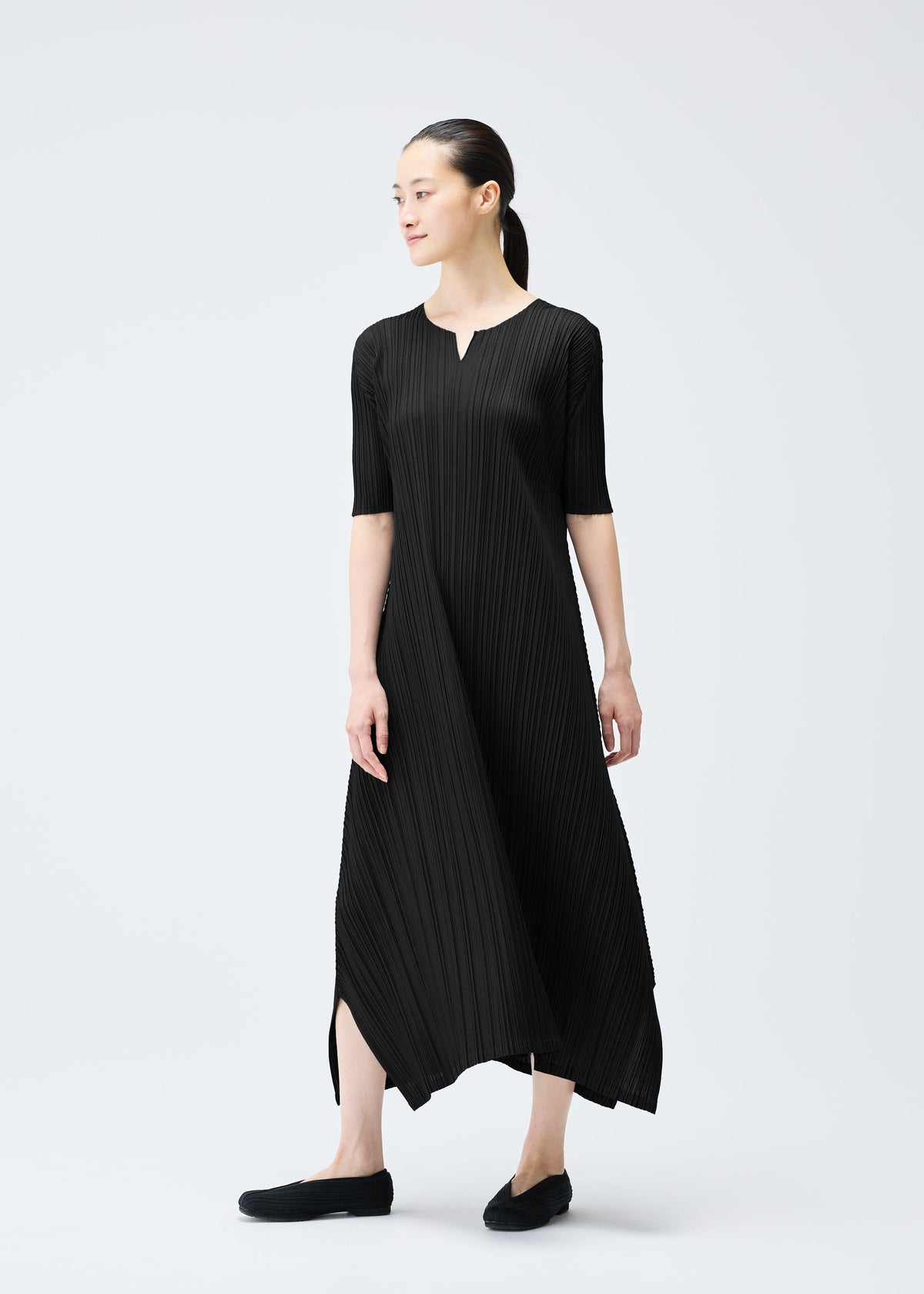 A model wears the PLEATS PLEASE ISSEY MIYAKE MELLOW PLEATS dress.