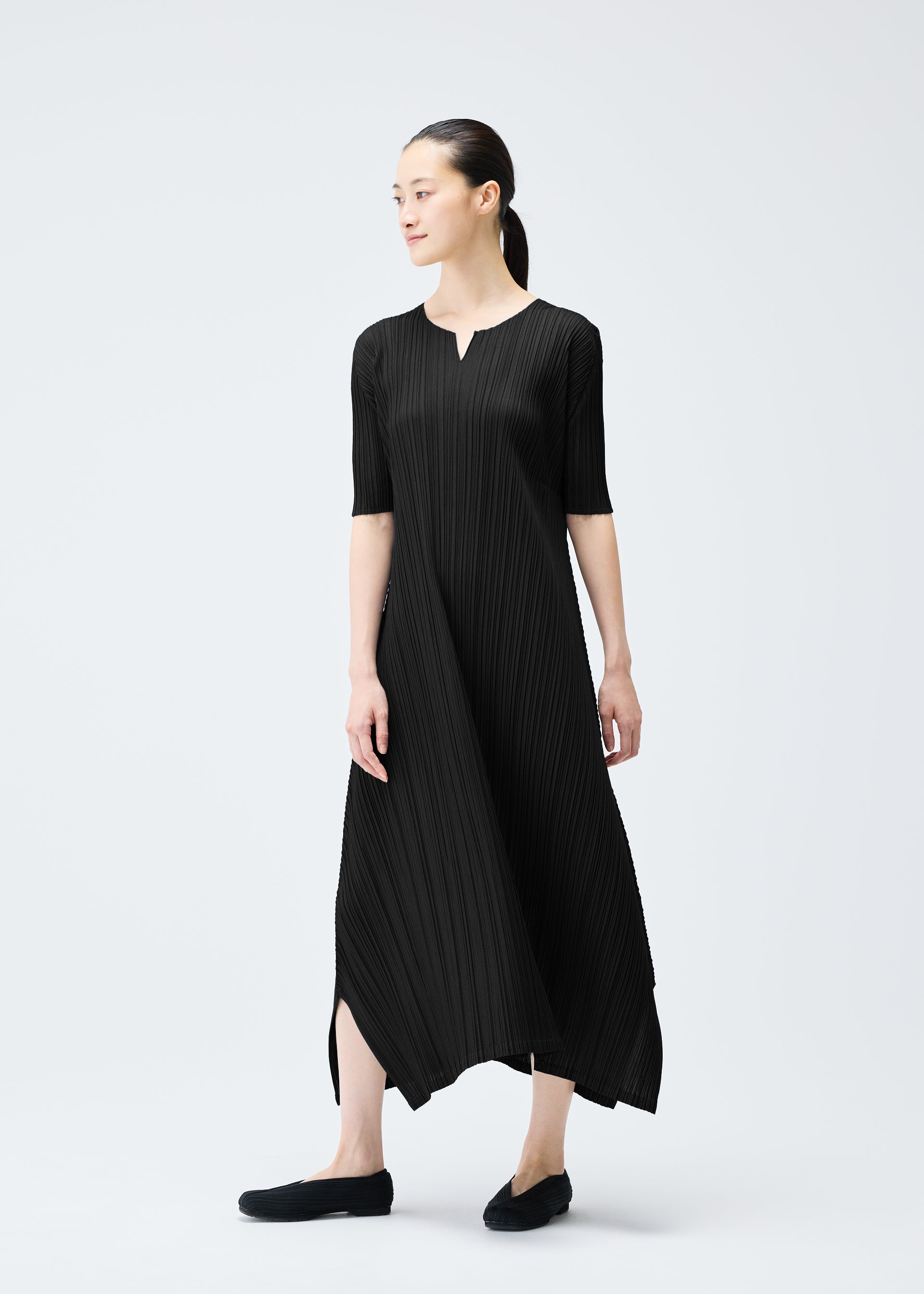 A model wears the PLEATS PLEASE ISSEY MIYAKE MELLOW PLEATS dress.