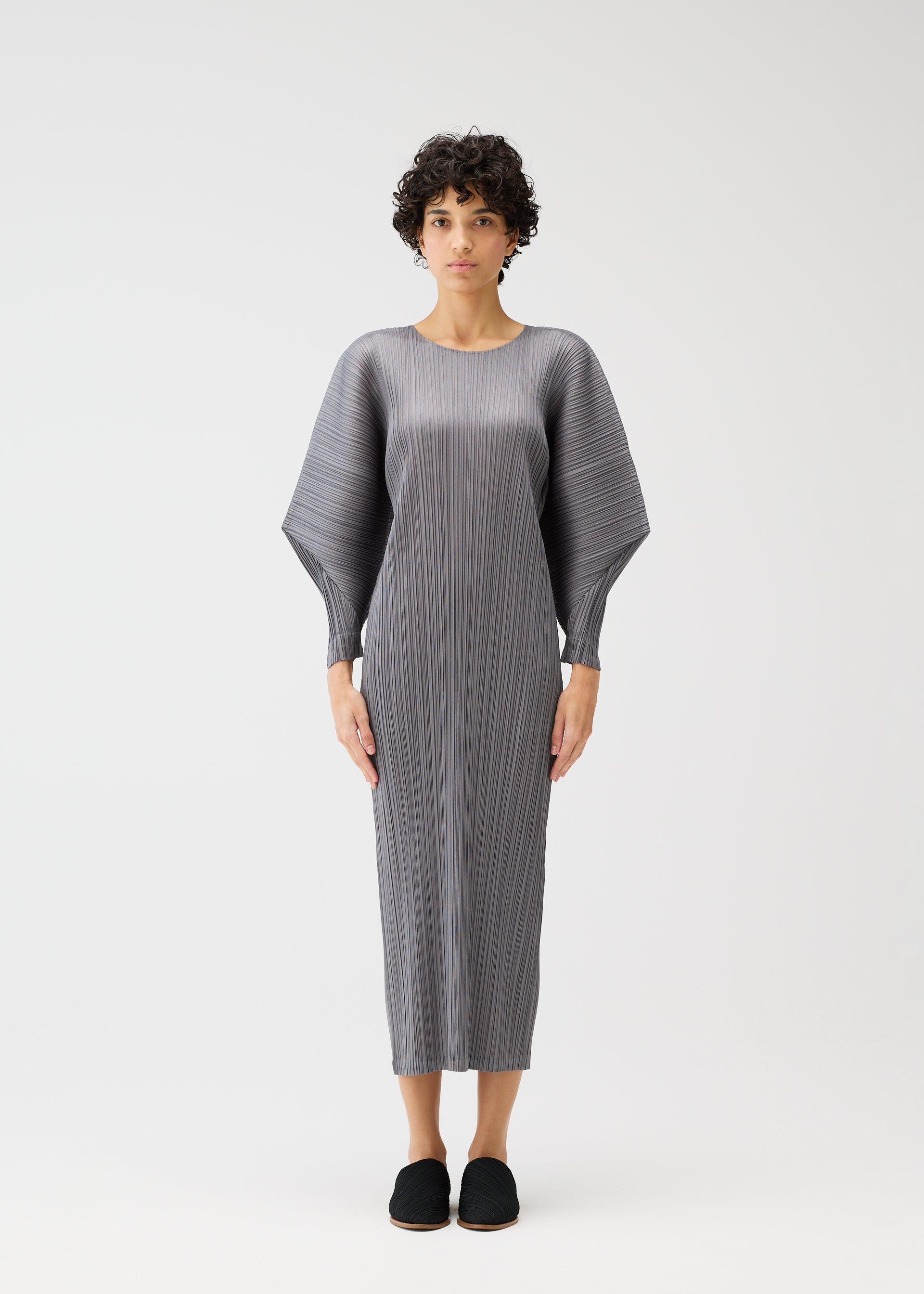 A model wears the PLEATS PLEASE ISSEY MIYAKE SKYLINE clothing.