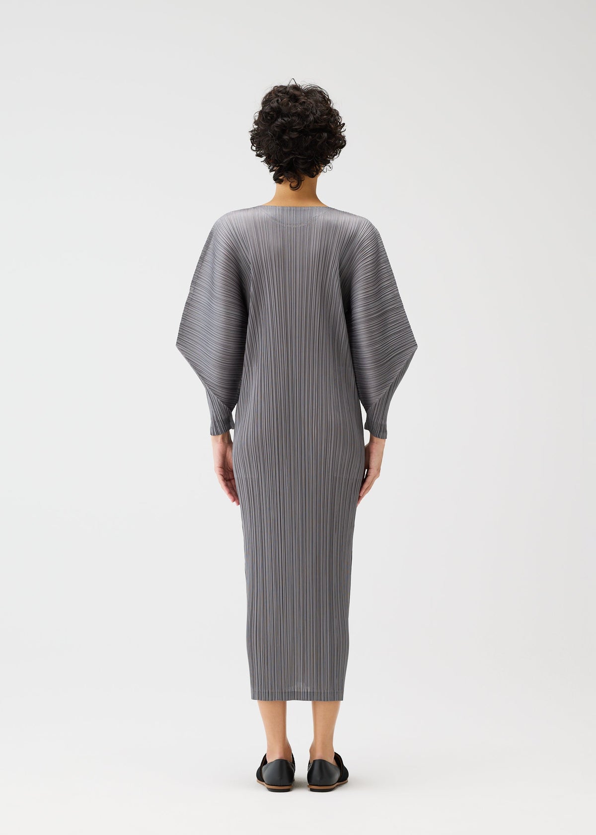 A model wears the PLEATS PLEASE ISSEY MIYAKE SKYLINE clothing.