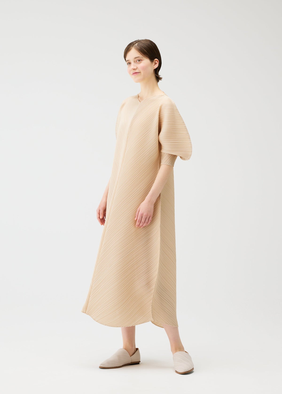 A model wears the PLEATS PLEASE ISSEY MIYAKE COAST dress.