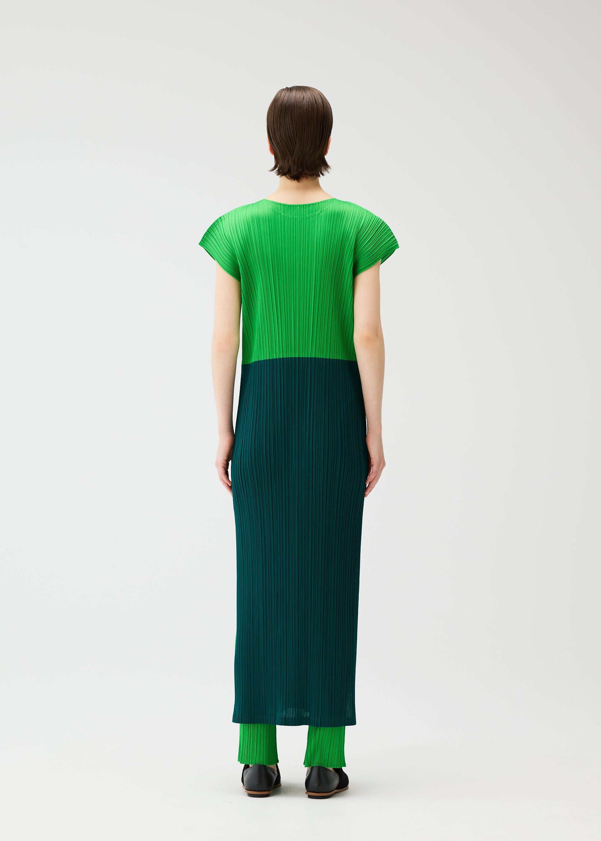 A model wears the PLEATS PLEASE ISSEY MIYAKE SWING dress.