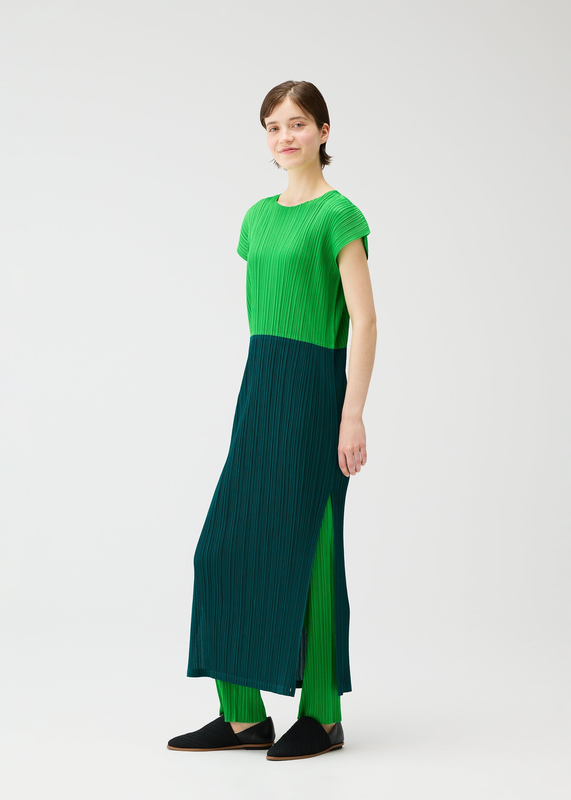 A model wears the PLEATS PLEASE ISSEY MIYAKE SWING dress.
