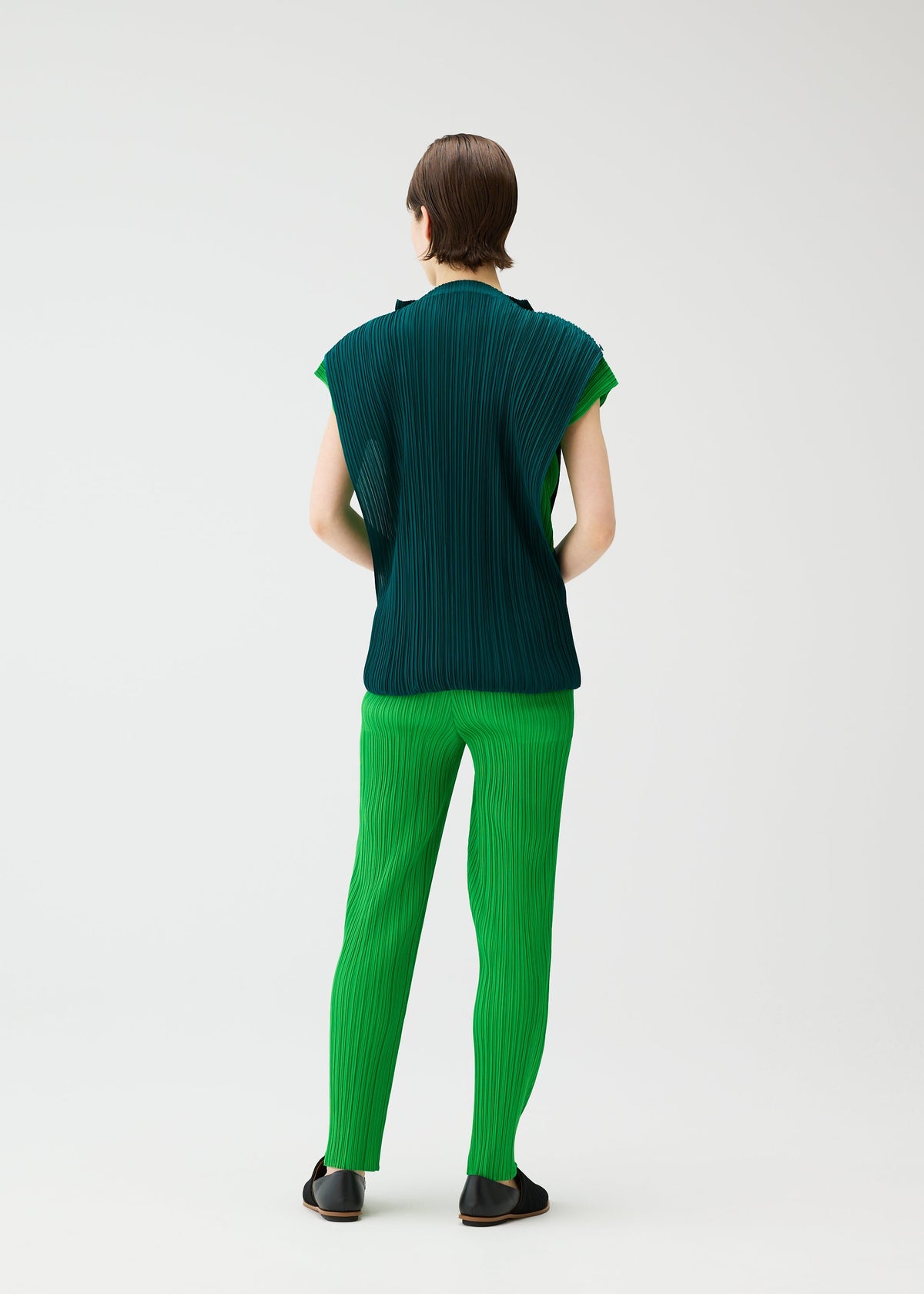 A model wears the PLEATS PLEASE ISSEY MIYAKE SWING dress.