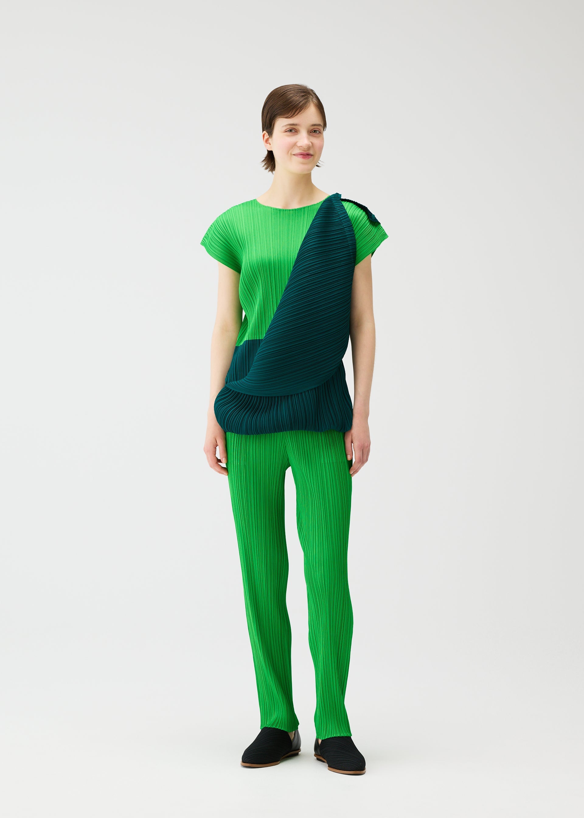 A model wears the PLEATS PLEASE ISSEY MIYAKE SWING dress.