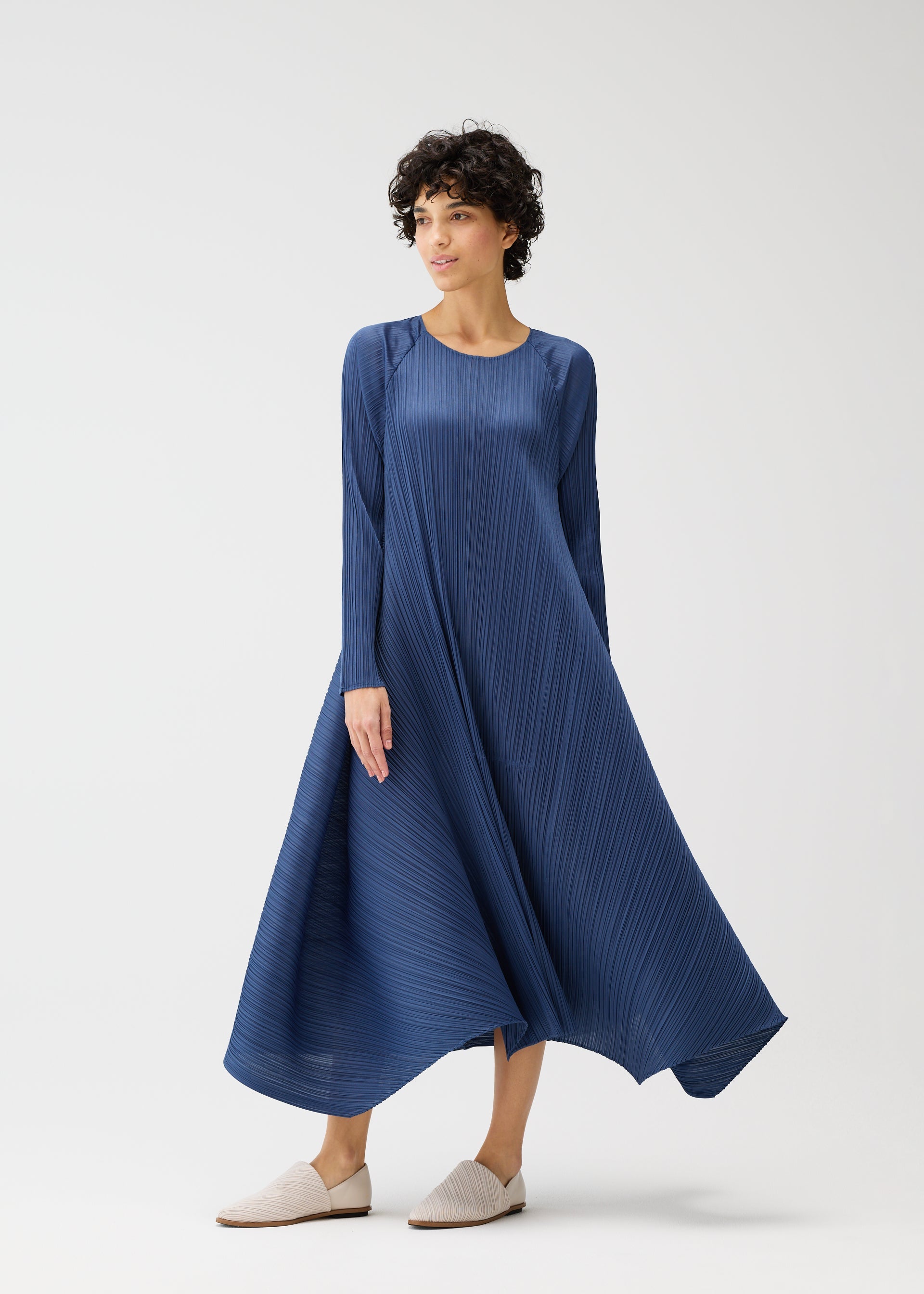 A model wears the PLEATS PLEASE ISSEY MIYAKE CITY FRAME dress.