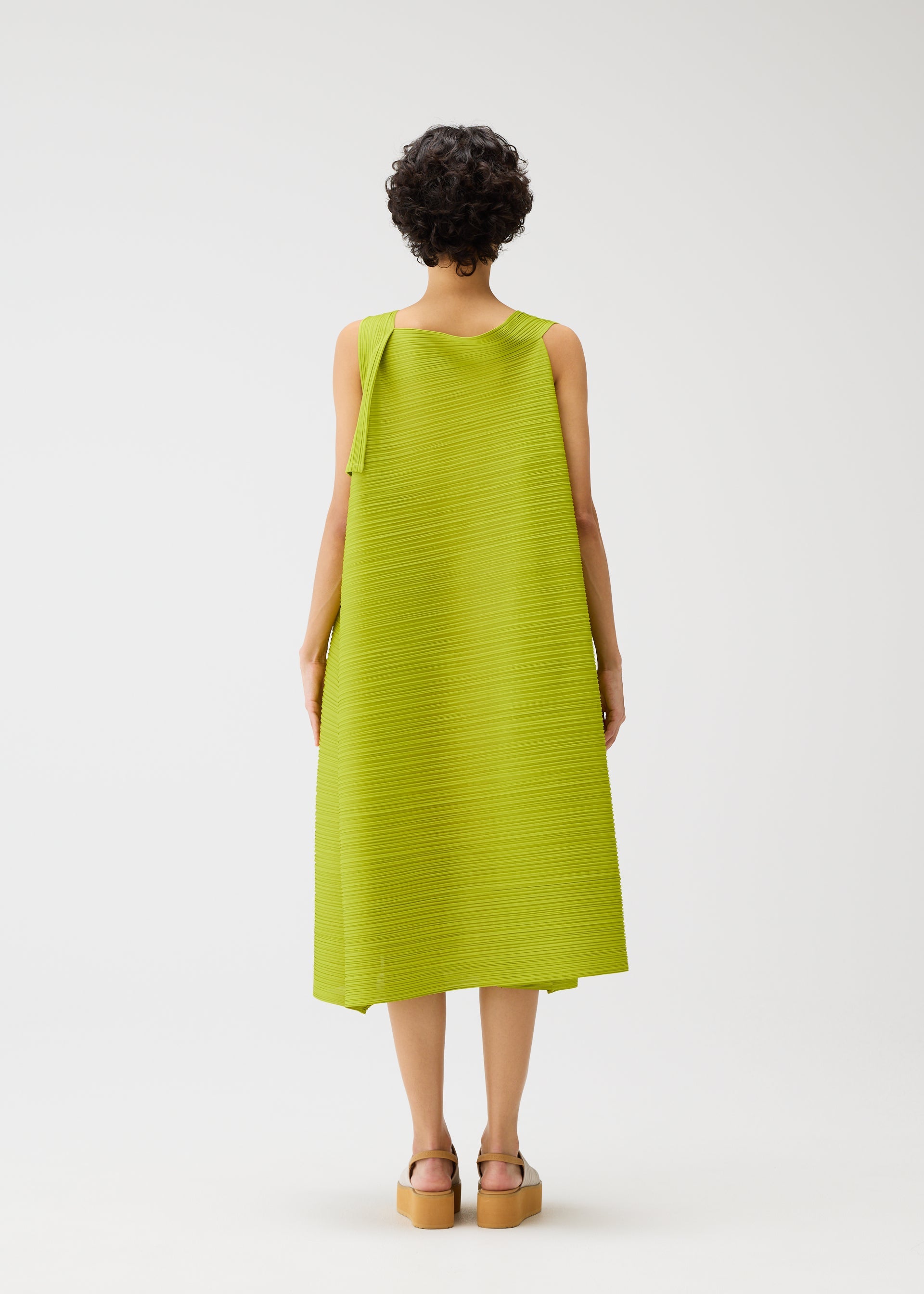 A model wears the PLEATS PLEASE ISSEY MIYAKE BOUNCY BASKET bouncy-basket-dress-yellow-green.