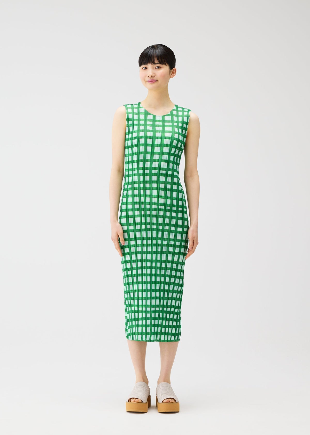 A model wears the PLEATS PLEASE ISSEY MIYAKE BASKET basket-dress-navy.