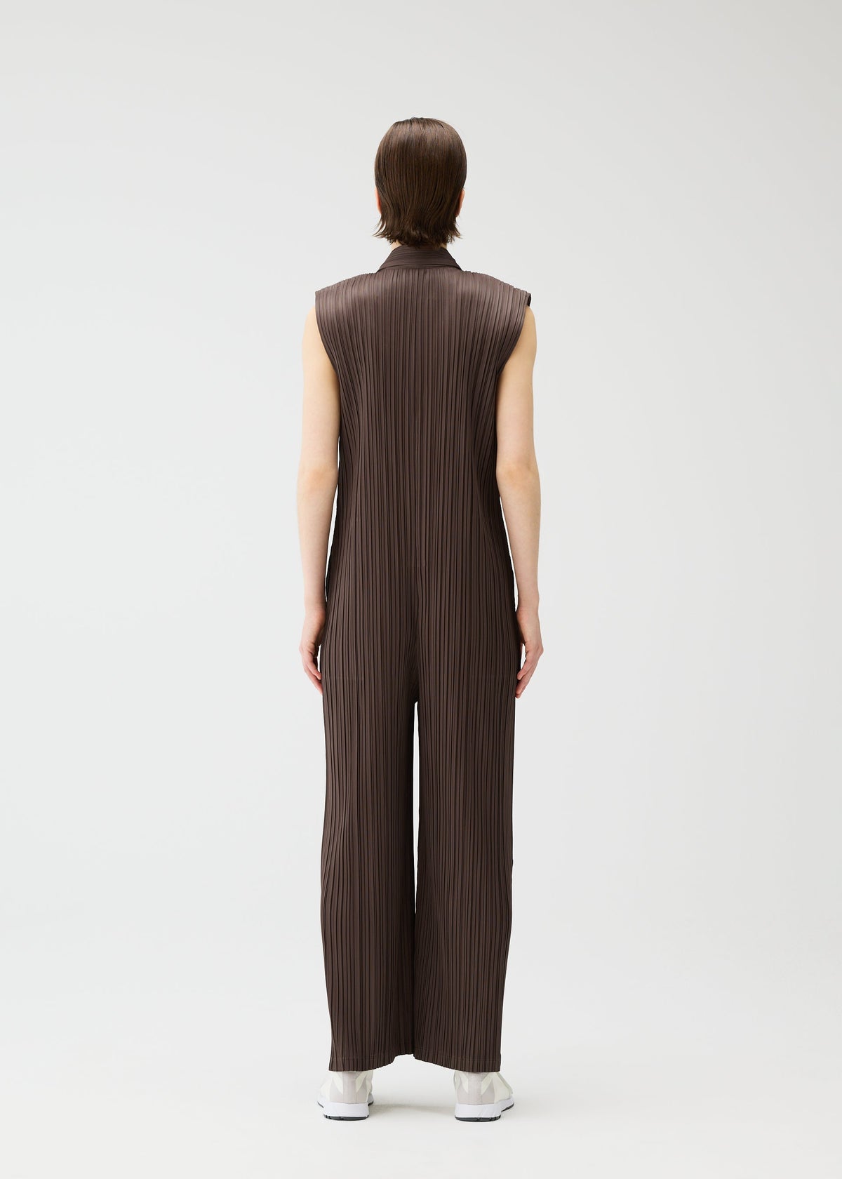A model wears the PLEATS PLEASE ISSEY MIYAKE LOOP BOTTOMS jumpsuit.