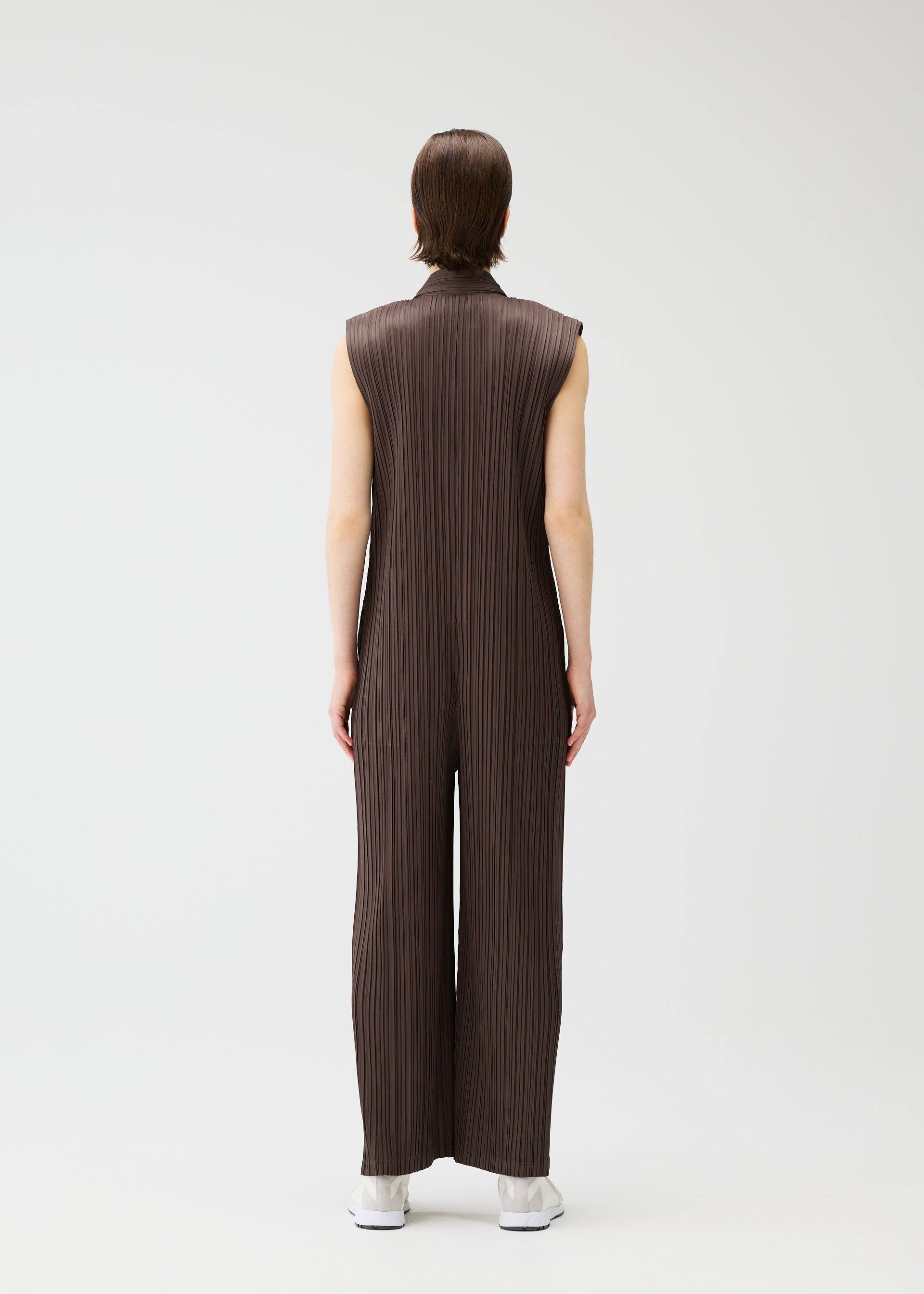 A model wears the PLEATS PLEASE ISSEY MIYAKE LOOP BOTTOMS jumpsuit.