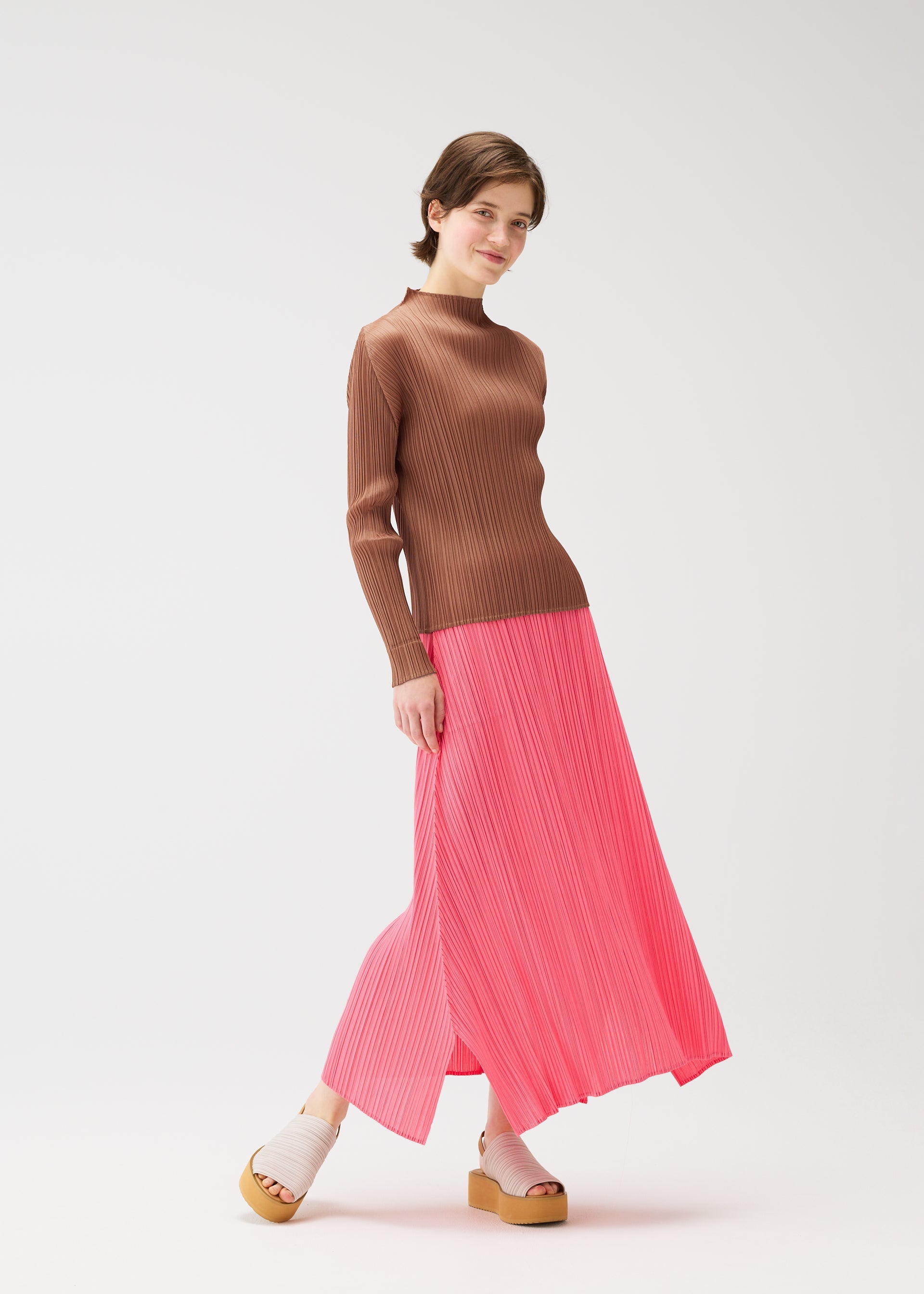 A model wears the PLEATS PLEASE ISSEY MIYAKE MONTHLY COLORS MARCH shirt.