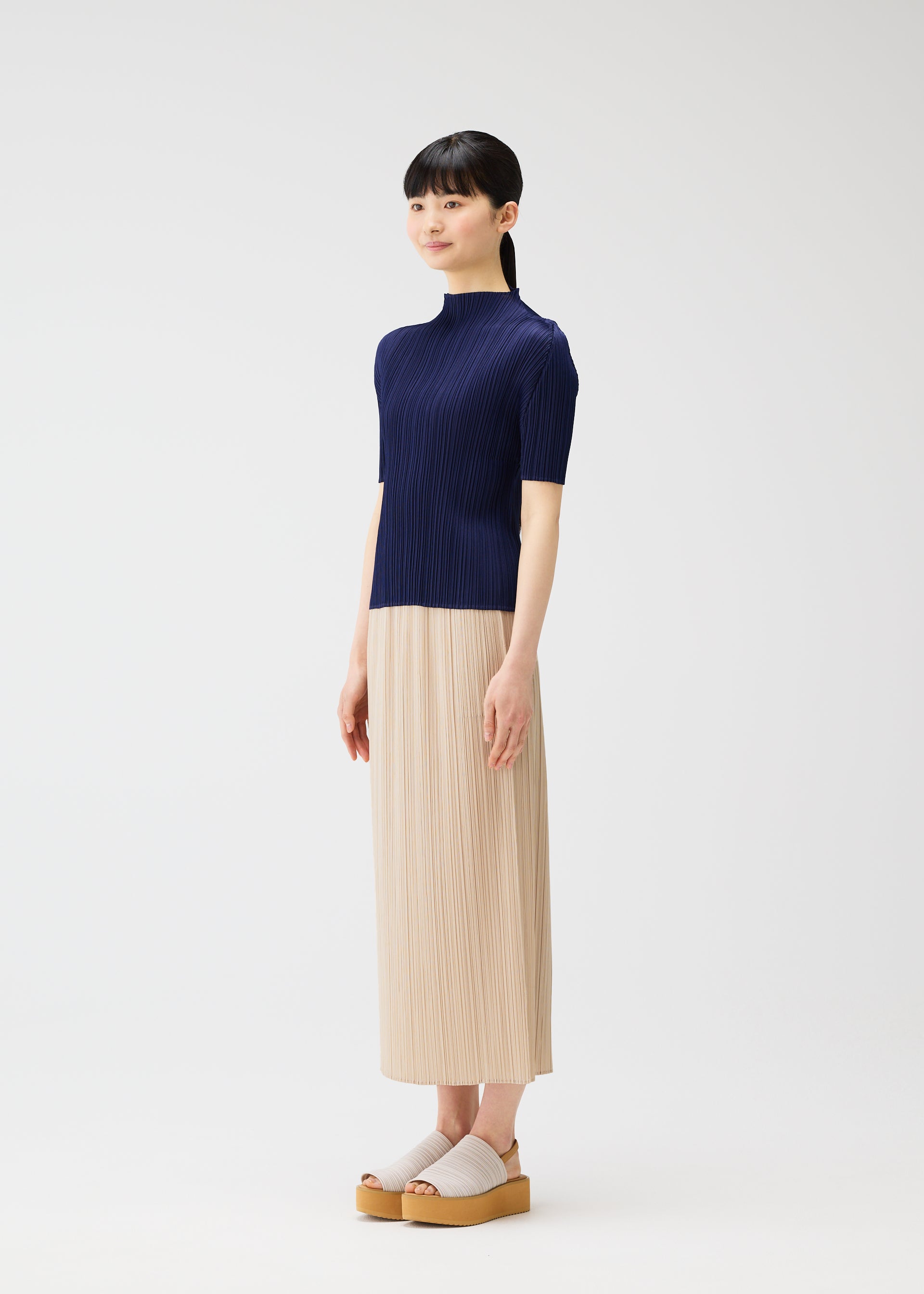 A model wears the PLEATS PLEASE ISSEY MIYAKE MONTHLY COLORS MAY top.