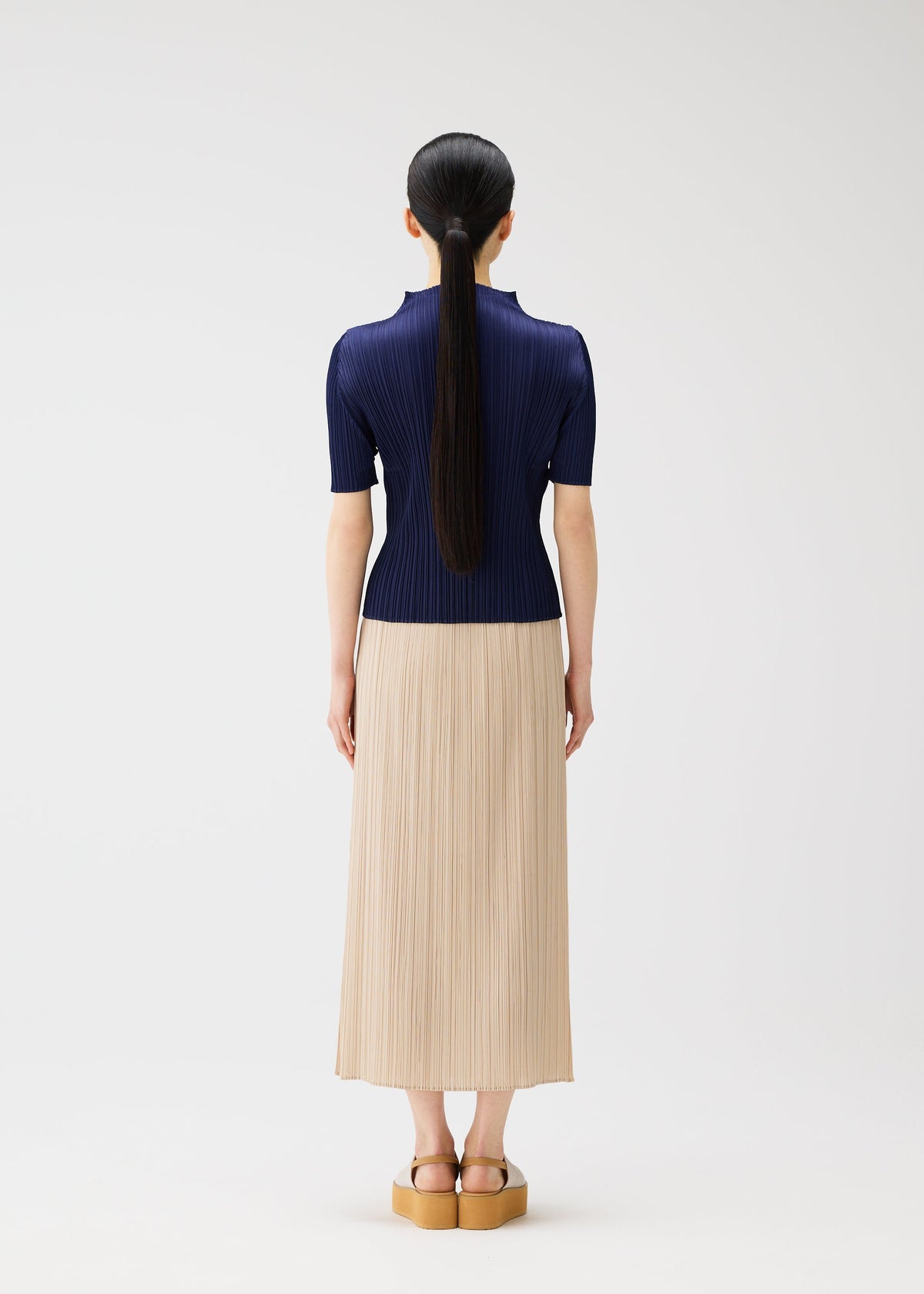 A model wears the PLEATS PLEASE ISSEY MIYAKE MONTHLY COLORS MAY top.