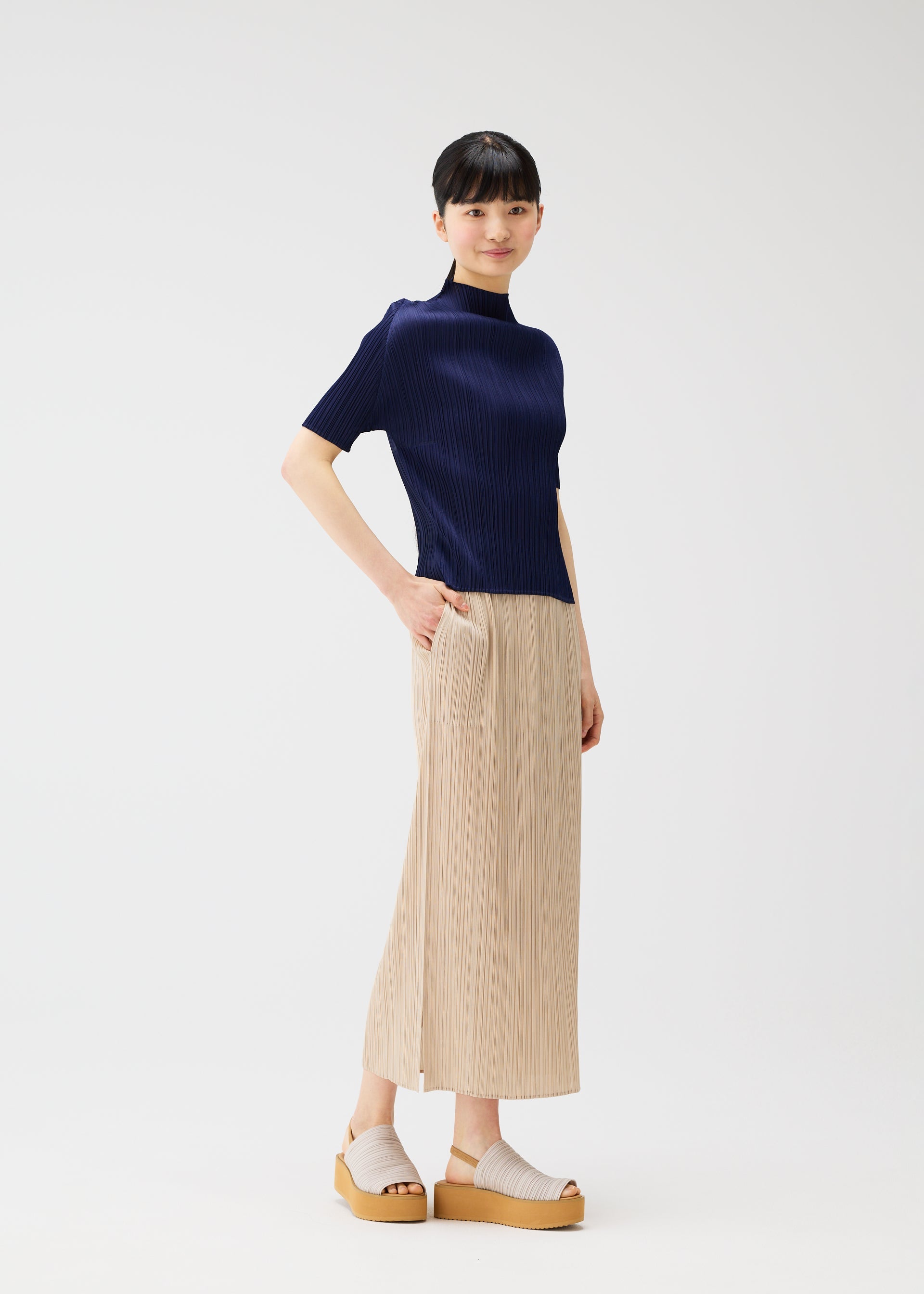 A model wears the PLEATS PLEASE ISSEY MIYAKE MONTHLY COLORS MAY top.