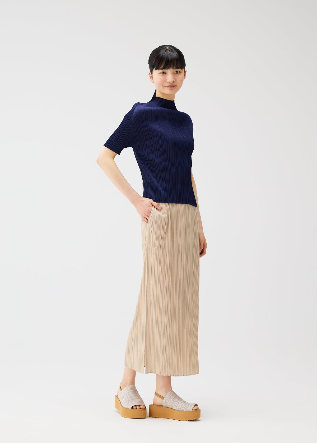 A model wears the PLEATS PLEASE ISSEY MIYAKE MONTHLY COLORS MAY top.
