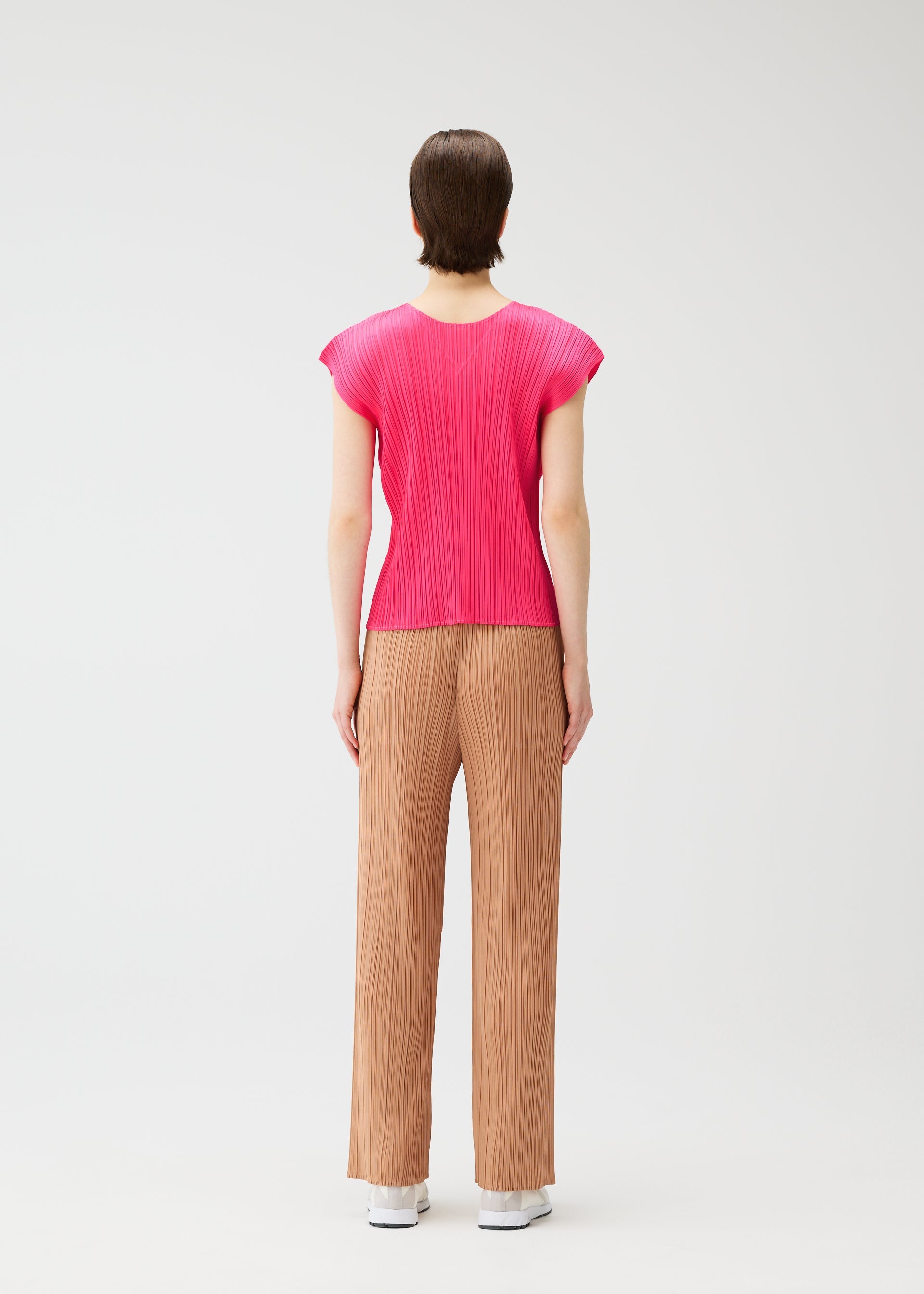 A model wears the PLEATS PLEASE ISSEY MIYAKE MONTHLY COLORS : JUNE monthly-colors-june-shirt-pink-beige.