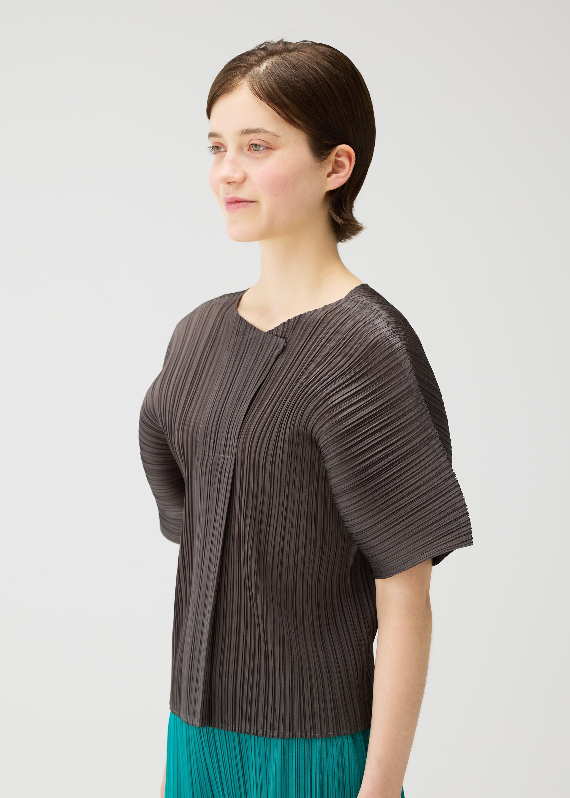 A model wears the PLEATS PLEASE ISSEY MIYAKE MONTHLY COLORS : JUNE monthly-colors-june-shirt-charcoal-1.