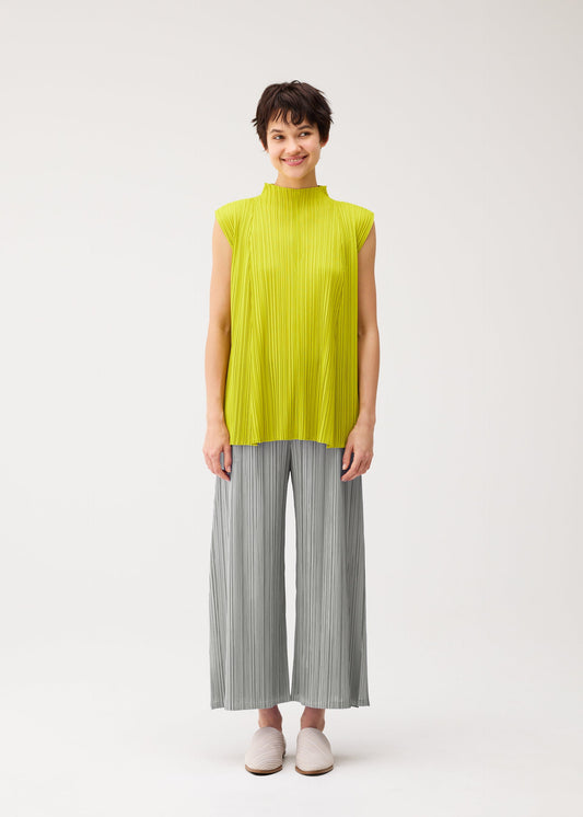 A model wears the PLEATS PLEASE ISSEY MIYAKE MELLOW PLEATS shirt.