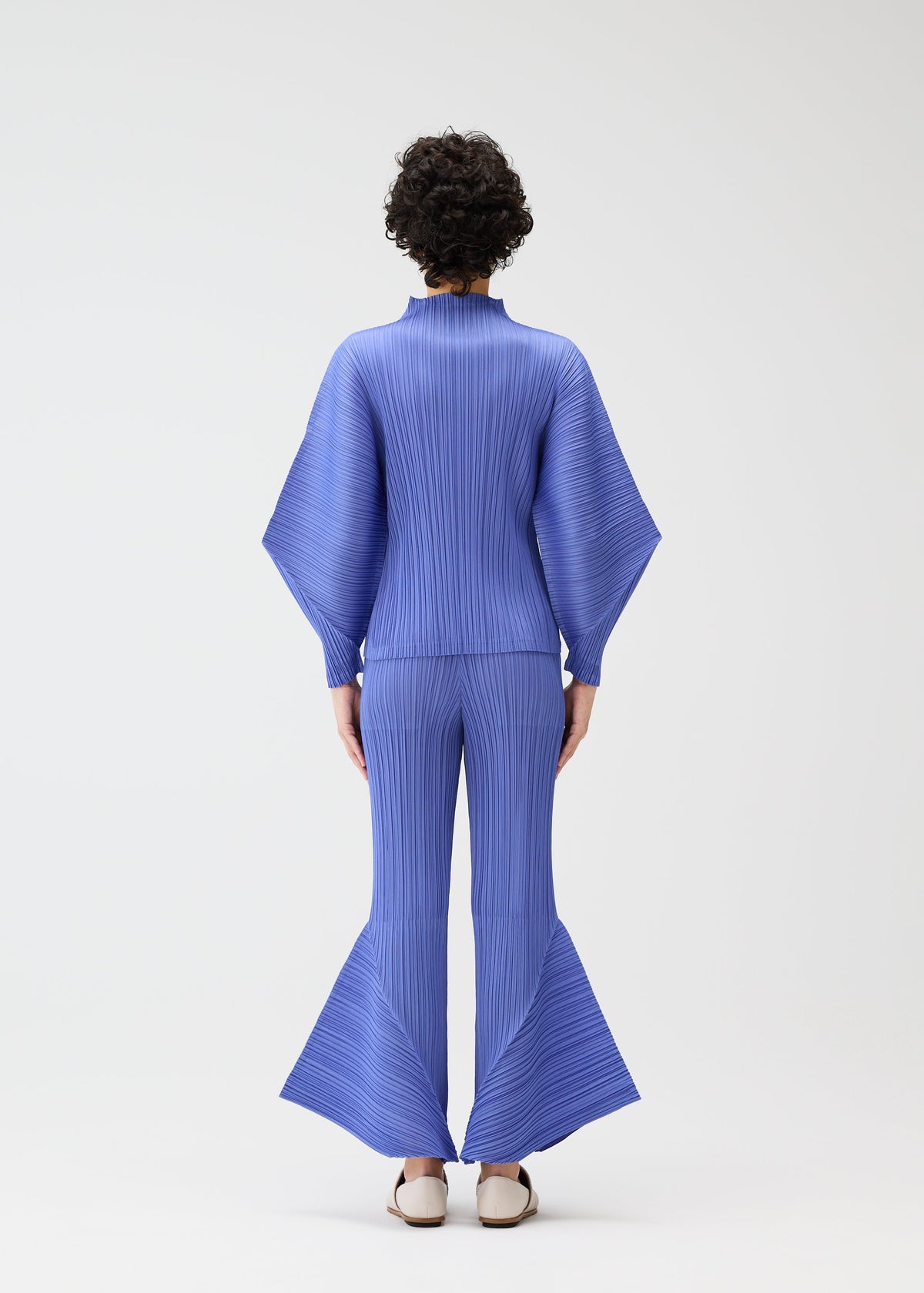 A model wears the PLEATS PLEASE ISSEY MIYAKE SKYLINE clothing.