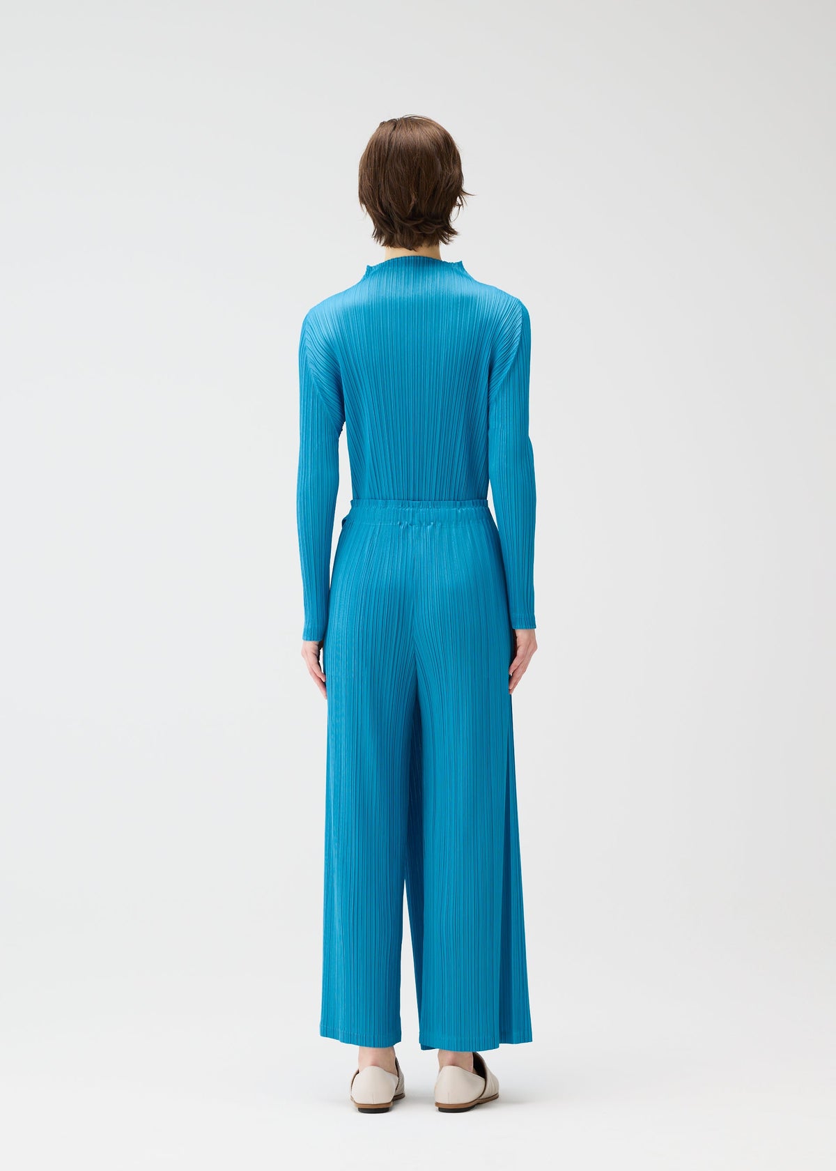 A model wears the PLEATS PLEASE ISSEY MIYAKE FACADE shirt.