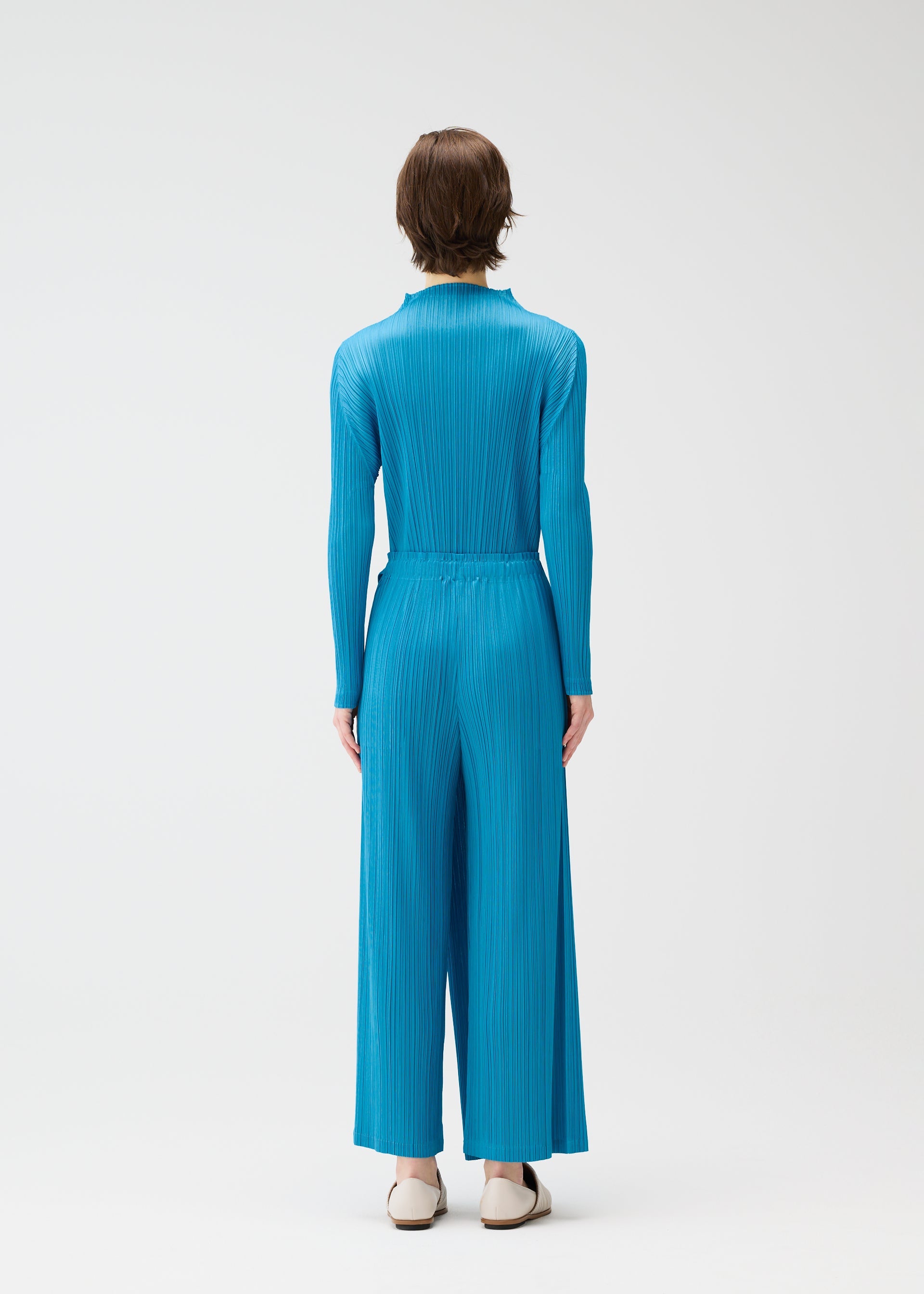 A model wears the PLEATS PLEASE ISSEY MIYAKE FACADE shirt.