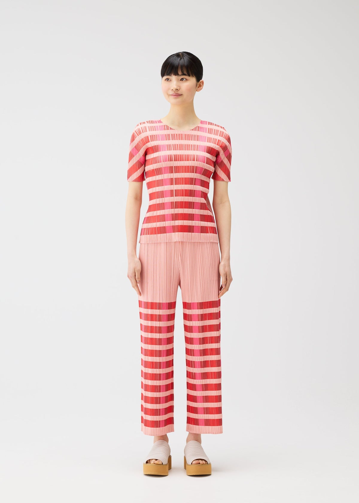 A model wears the PLEATS PLEASE ISSEY MIYAKE BUMPY BASKET bumpy-basket-shirt-green.