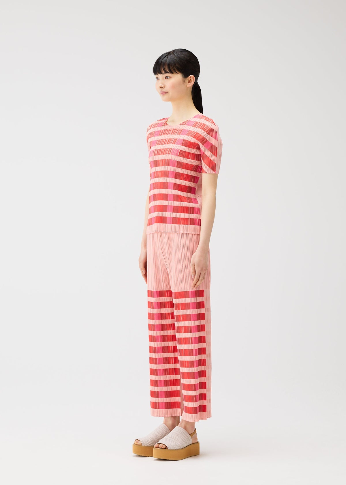 A model wears the PLEATS PLEASE ISSEY MIYAKE BUMPY BASKET bumpy-basket-shirt-green.