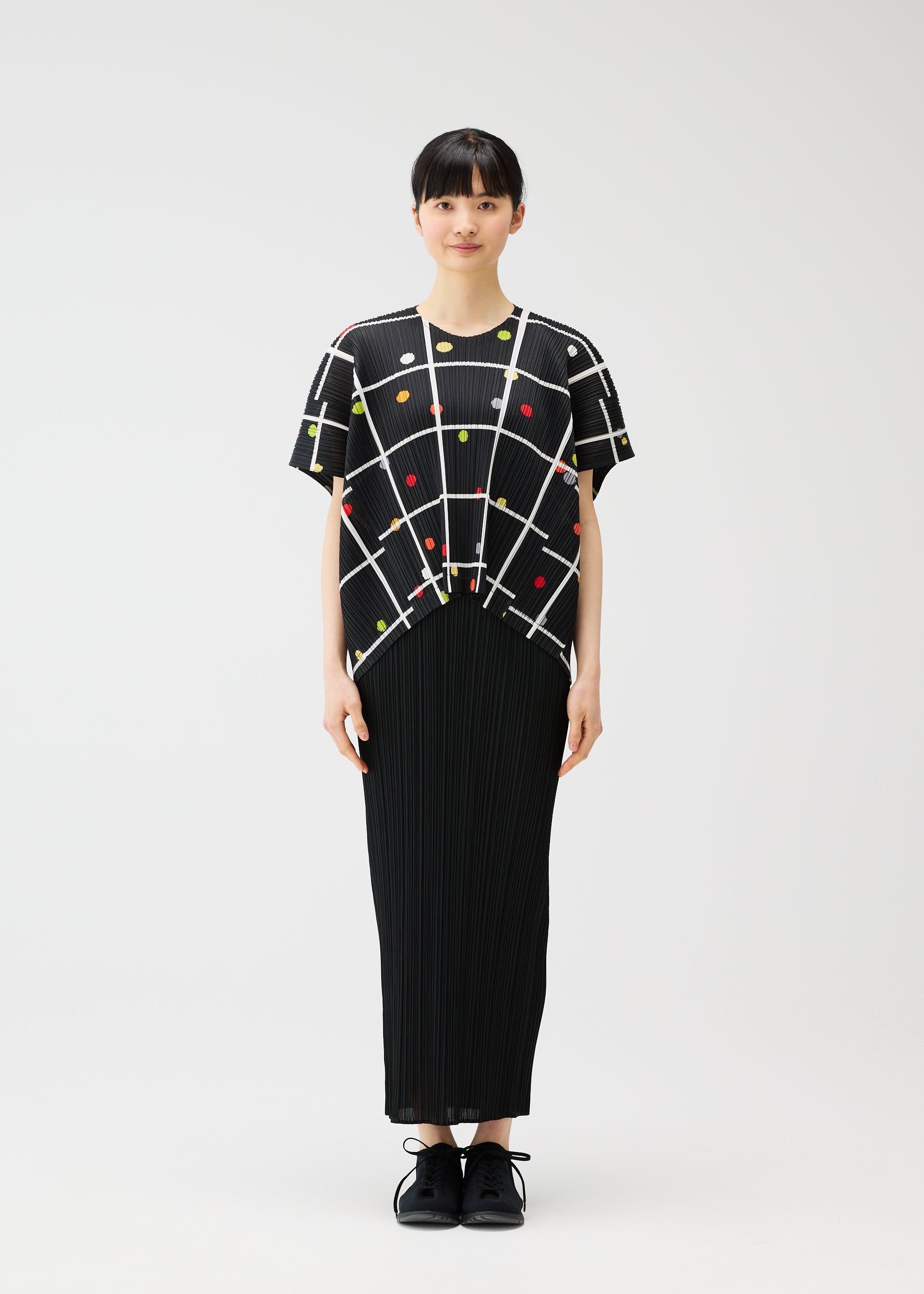 A model wears the PLEATS PLEASE ISSEY MIYAKE CROSSING DOTS shirt.