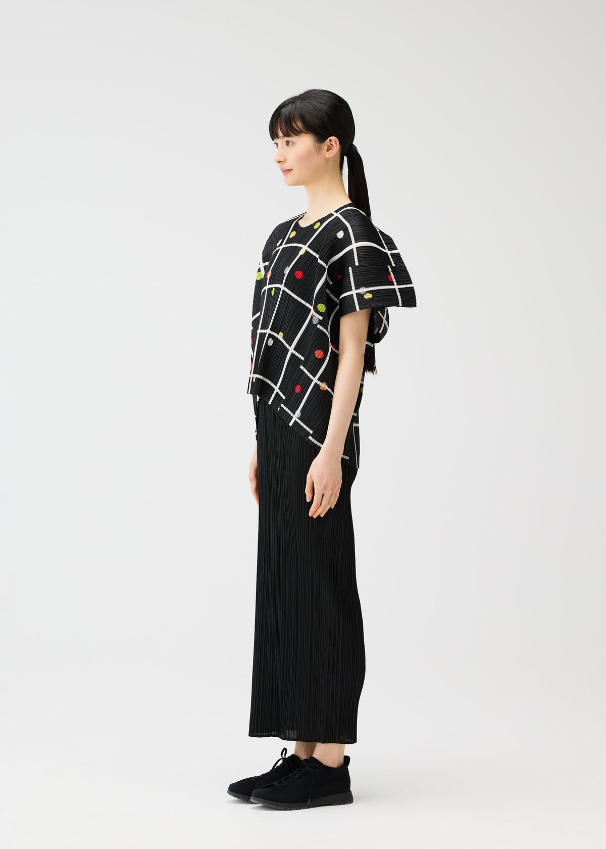 A model wears the PLEATS PLEASE ISSEY MIYAKE CROSSING DOTS shirt.